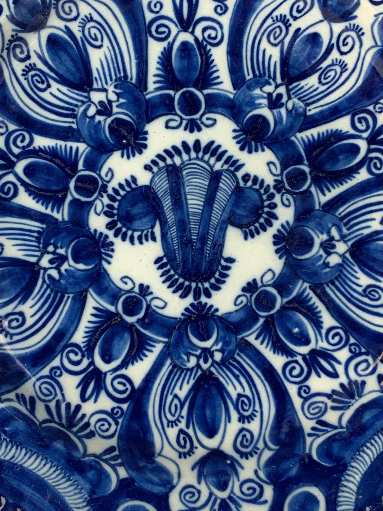 Ce chargeur ancien de Delft hollandais a été peint à la main au XVIIIe siècle chez De Vergulde Bloempot, l'une des fabriques de Delft les plus estimées de l'époque.
Elle porte au revers les initiales 