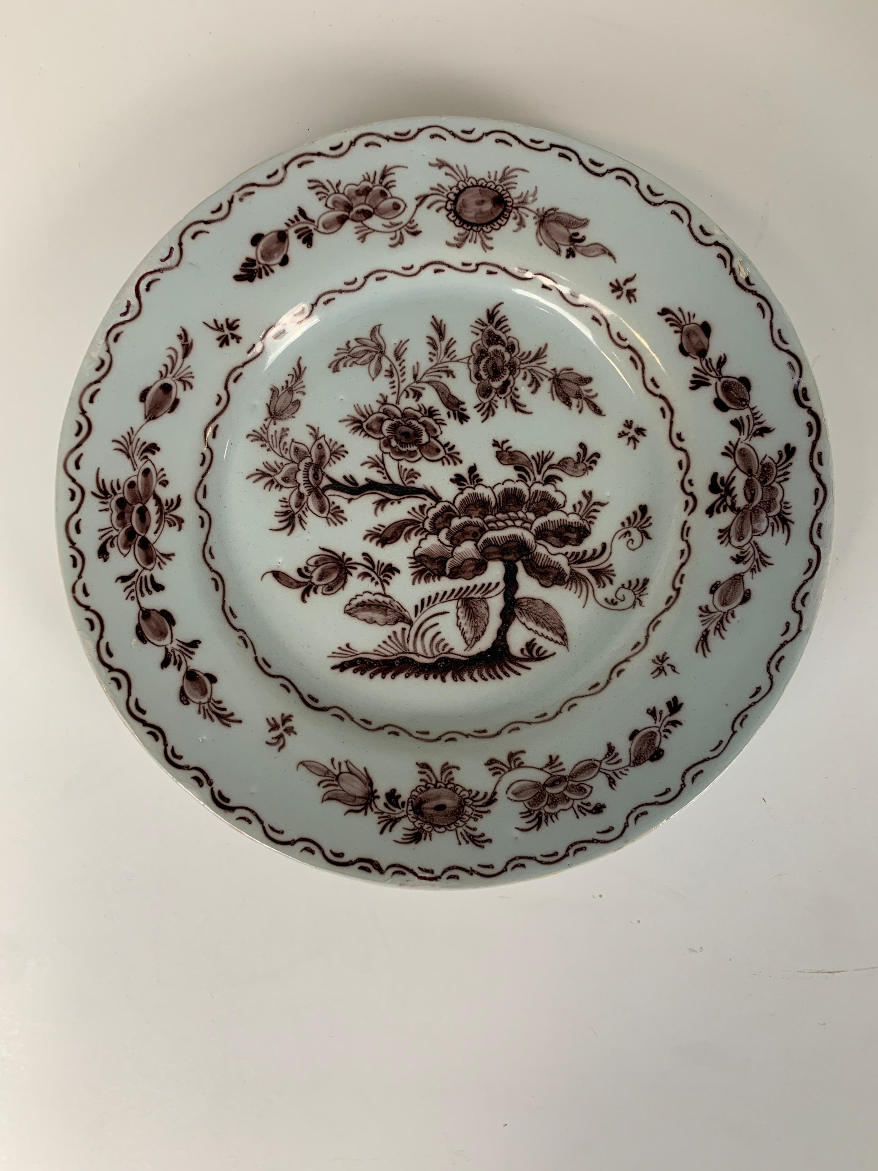 A set of five antique Dutch Delft dishes beautifully hand painted with manganese-based purple.
 The dishes show a peony plant in full bloom. 
The maker was Hugo Brouwer. Brouwer created the design, and each dish would have been hand-painted in his