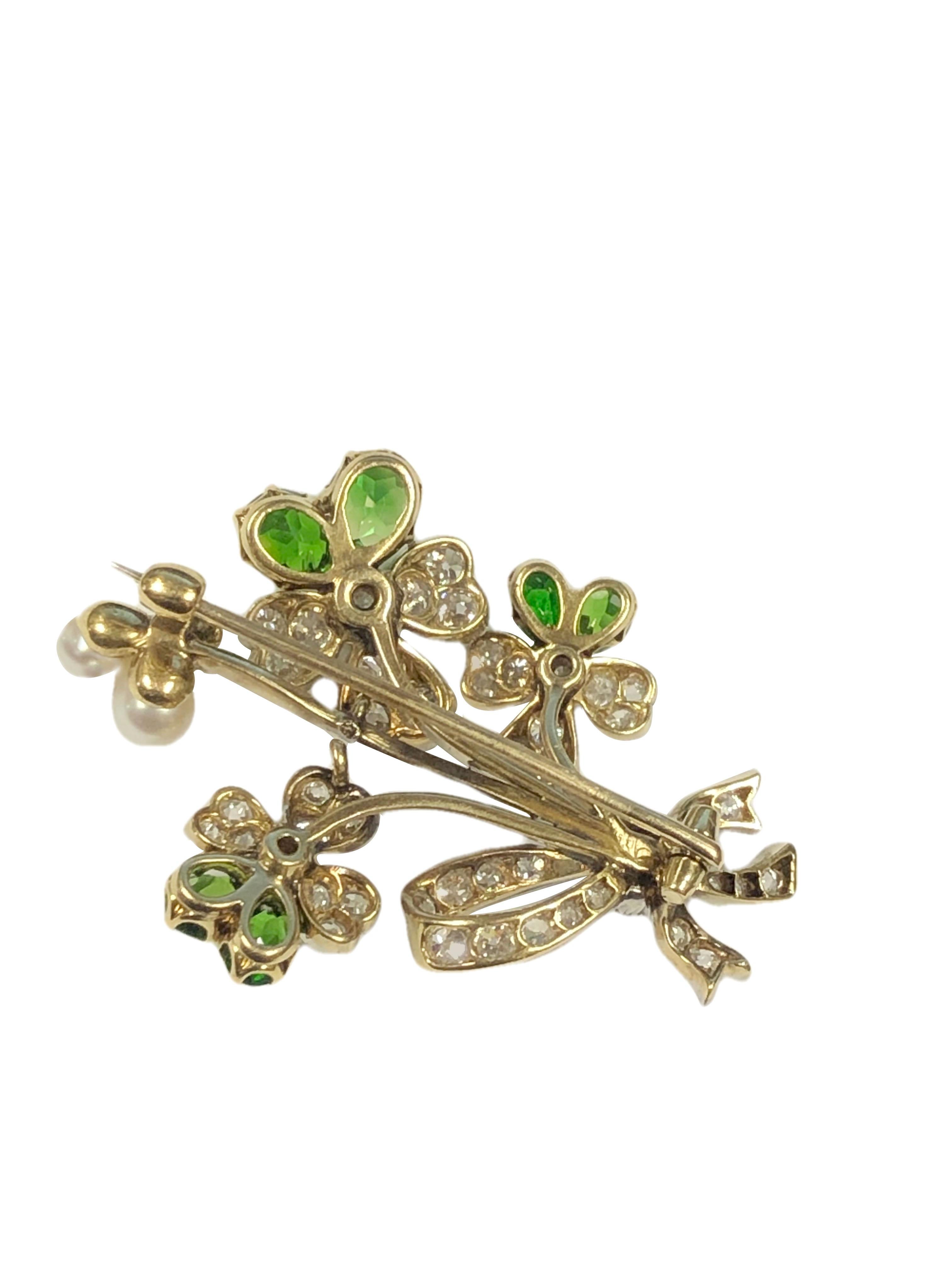 Circa 1920 Platinum and Diamond brooch, in a flower grouping form, measuring 1 5/8 inches in length X 1 1/8 inches. Set with Phenomenal intense Gem color Demantoid Garnets that are most likely Russian from the Ural region, the larger two are old cut