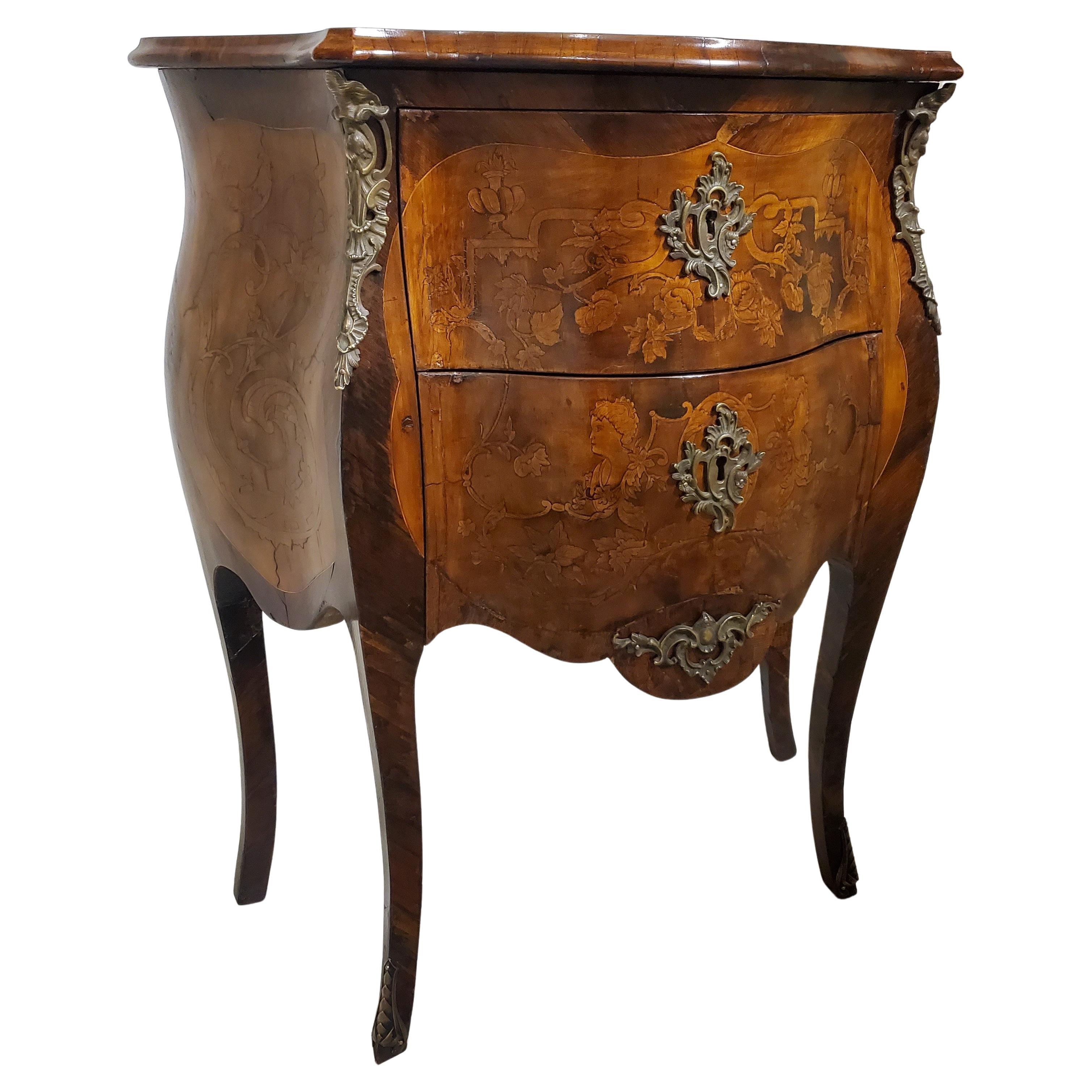 This LV style antique cabinet features exquisite parquetry with inlaid details gracing all four sides, even the top! Its two bombe drawers and serpentine shaped top with beveled edge create a striking visual appeal. The cabinet is further