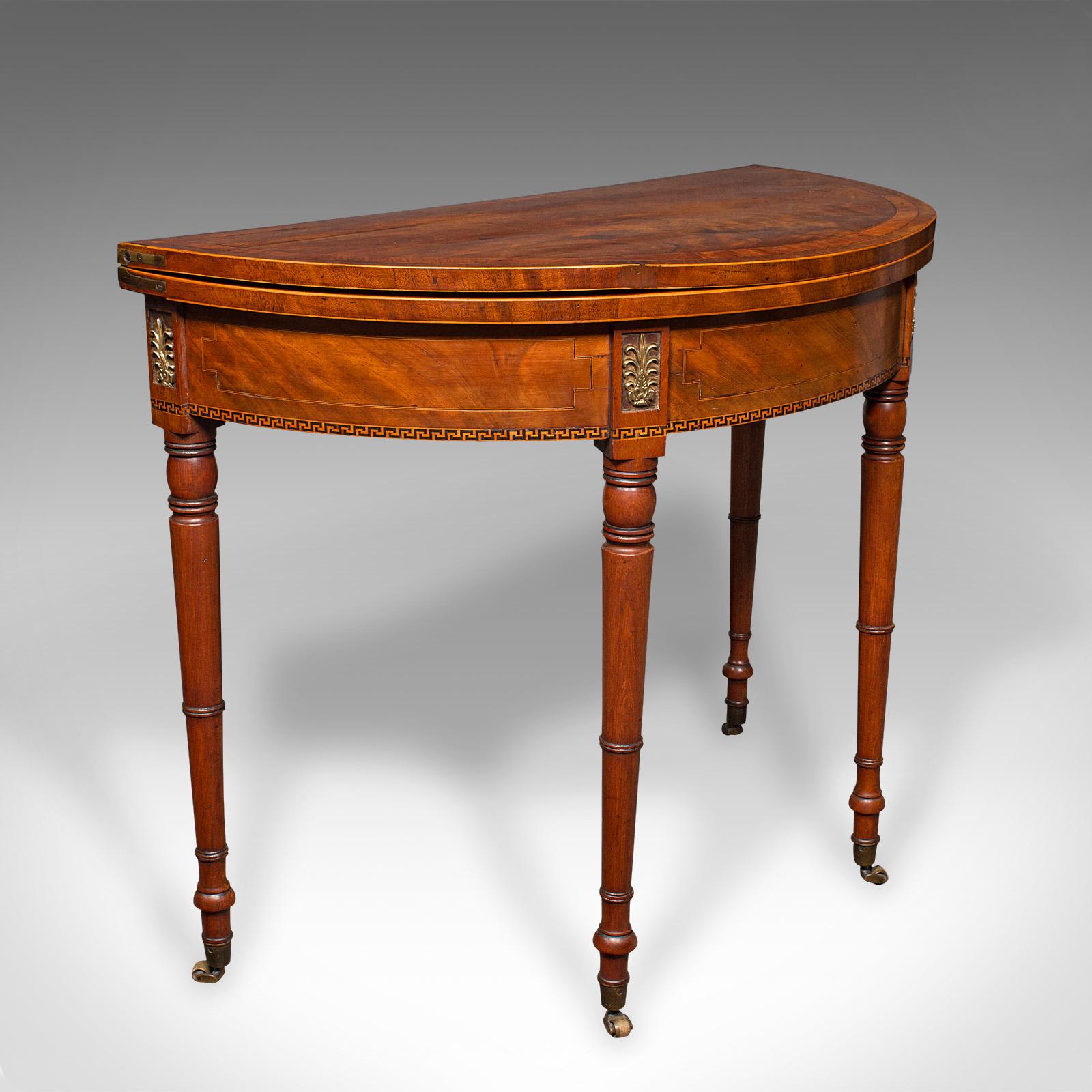 This is an antique demi-lune table. An English, walnut and satinwood fold over card table, dating to the Georgian period, circa 1800.

Beautiful Georgian craftsmanship for the finest gentleman's lounge
Displaying a desirable aged patina and in