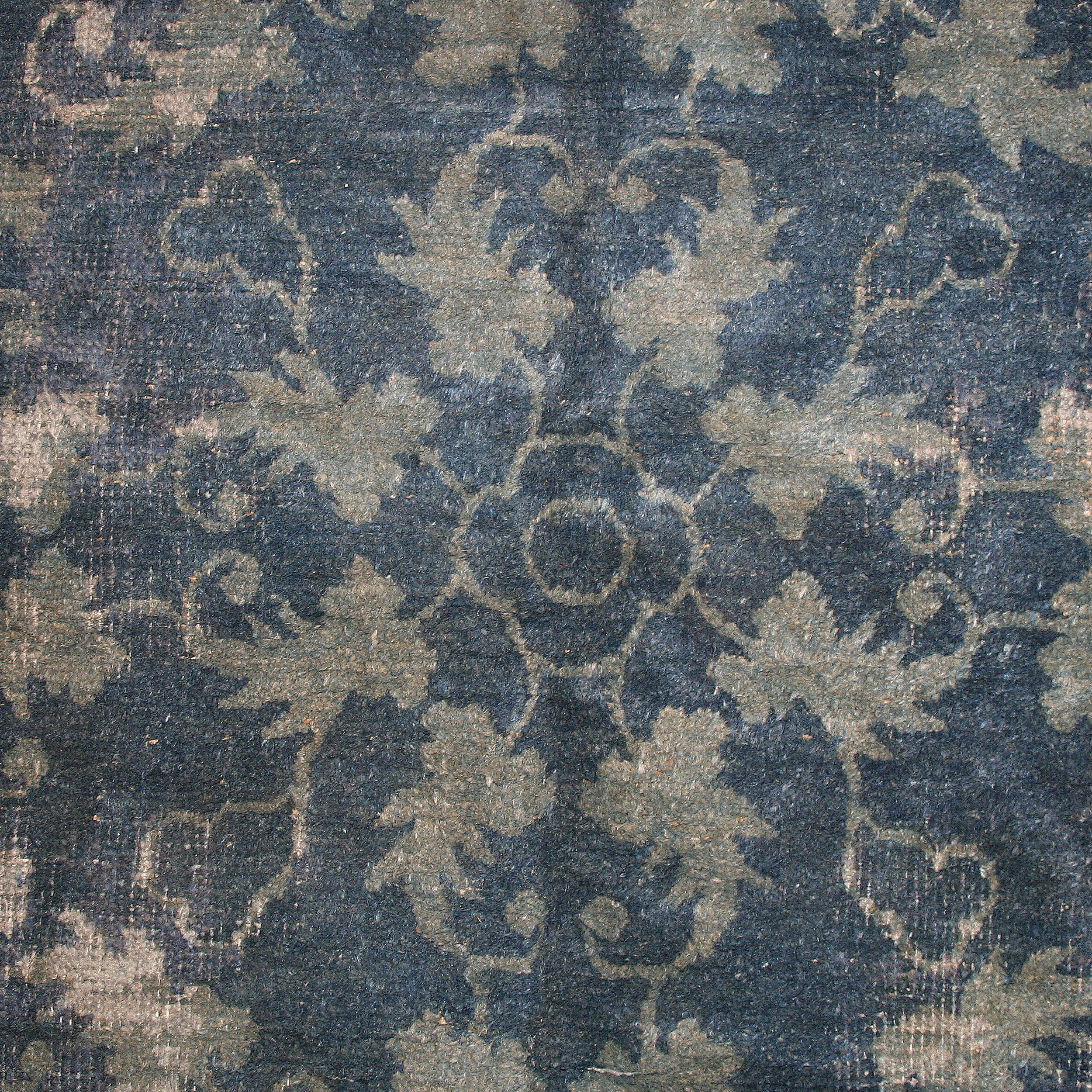 Una alfombra china antigua de gran refinamiento, que se distingue por un sutil dibujo tono sobre tono de hojas enrolladas en azul celeste sobre fondo azul vaquero, que recuerda a la porcelana imperial más sofisticada del periodo Ming. La lana sedosa
