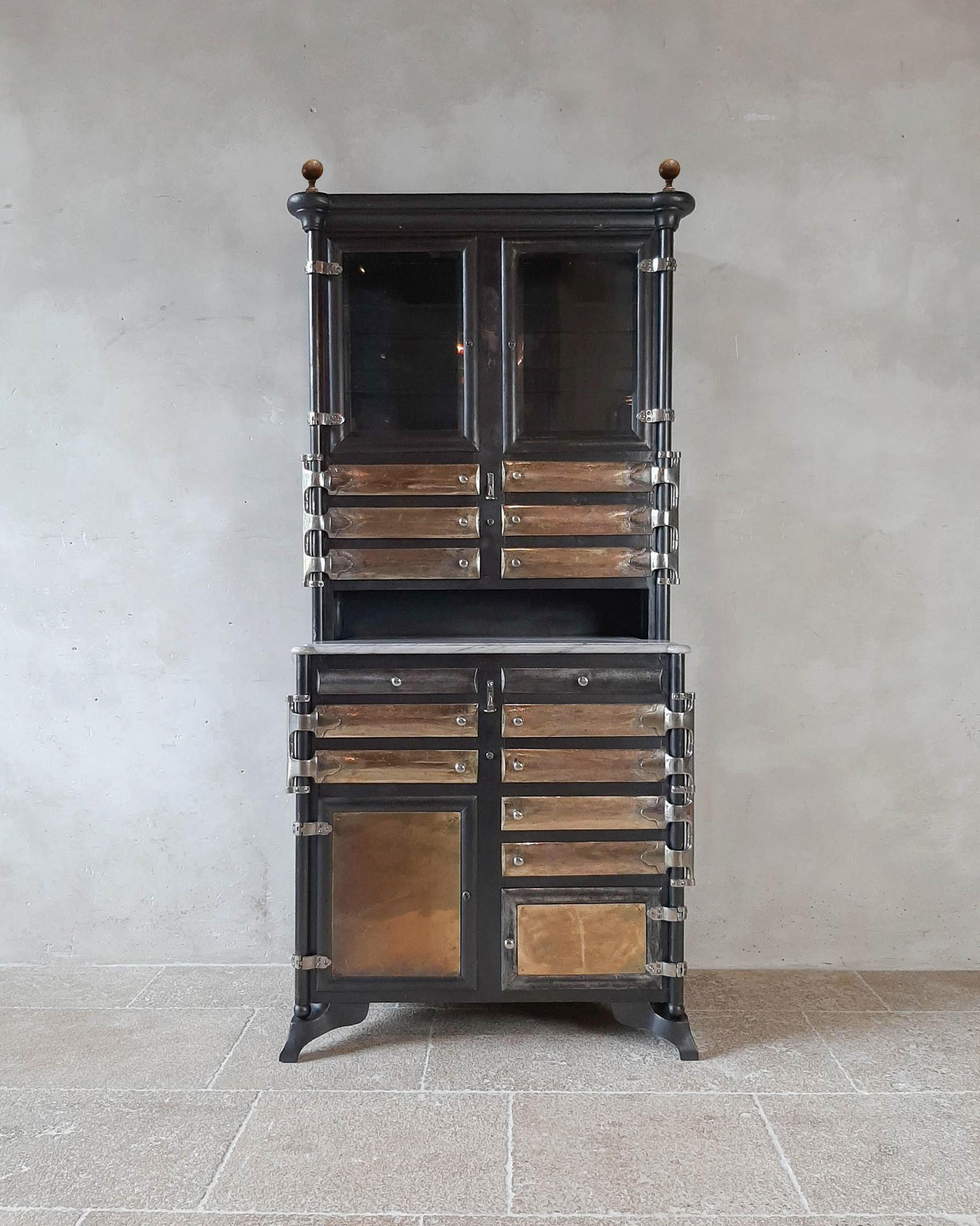 Antique metal dentist or medical cabinet. Heavy quality polished gunblack metal. The cabinet has a marble top, nickel hardware and hinges, and doors laid in with bevelled glass.

Vintage iron furniture, robust and elegant at the same
