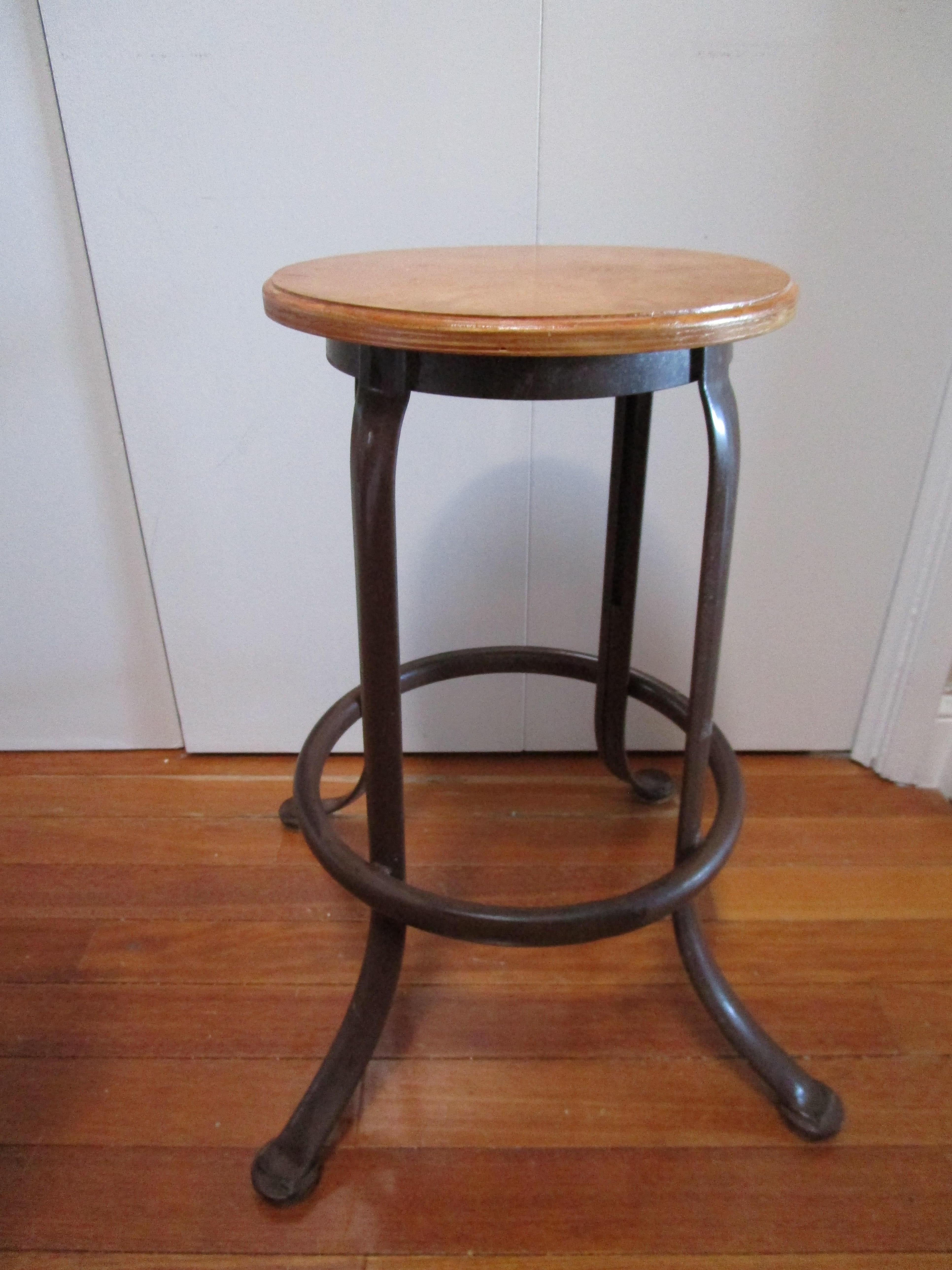 Il s'agit d'un magnifique tabouret industriel ancien avec quatre pieds qui se terminent par des pieds en forme de penny et un siège en érable. Il est robuste et le bois a une belle patine qui s'est développée au fil des ans. Le fabricant est