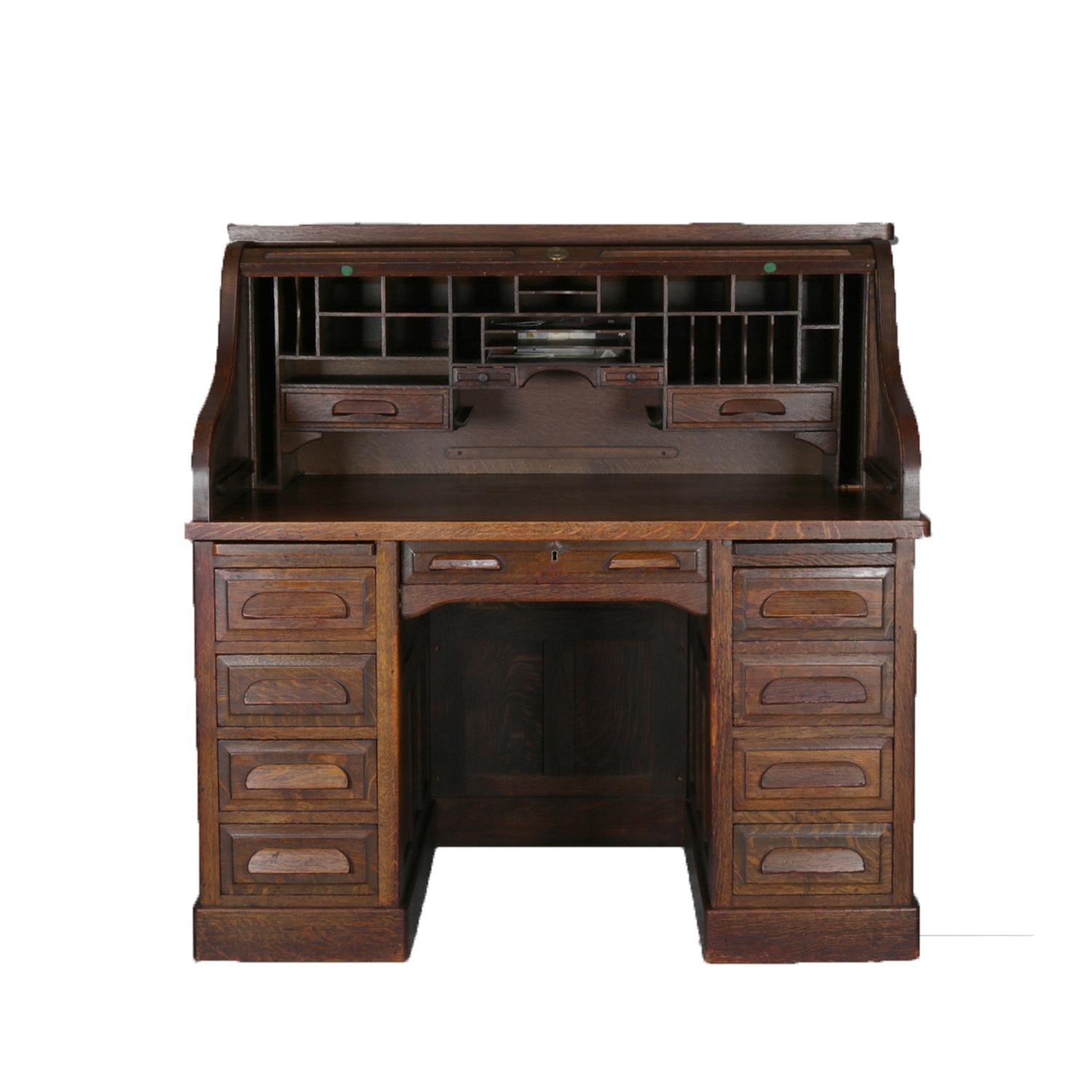 An antique Derby style roll top desk by Standard features roll top opening to reveal writing surface surmounted by pigeon holes and storage drawers over paneled cabinet with drawers and pull outs working surfaces, circa 1900

Measures: 50