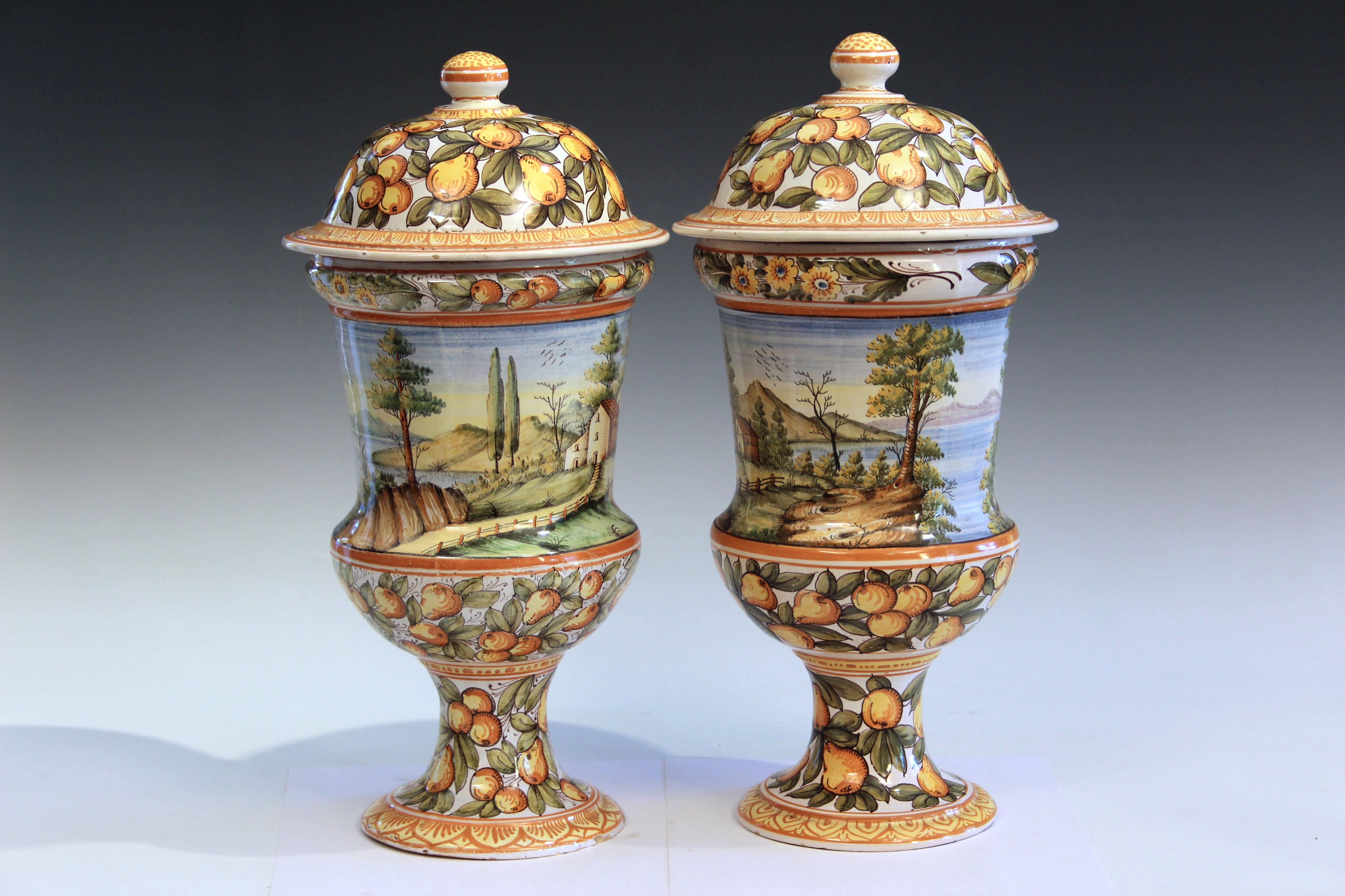 Old pair Deruta majolica pottery covered urn jars, circa early/mid 20th century. Hand painted all around with country landscape scenes of lakes and mountains. 16 1/2