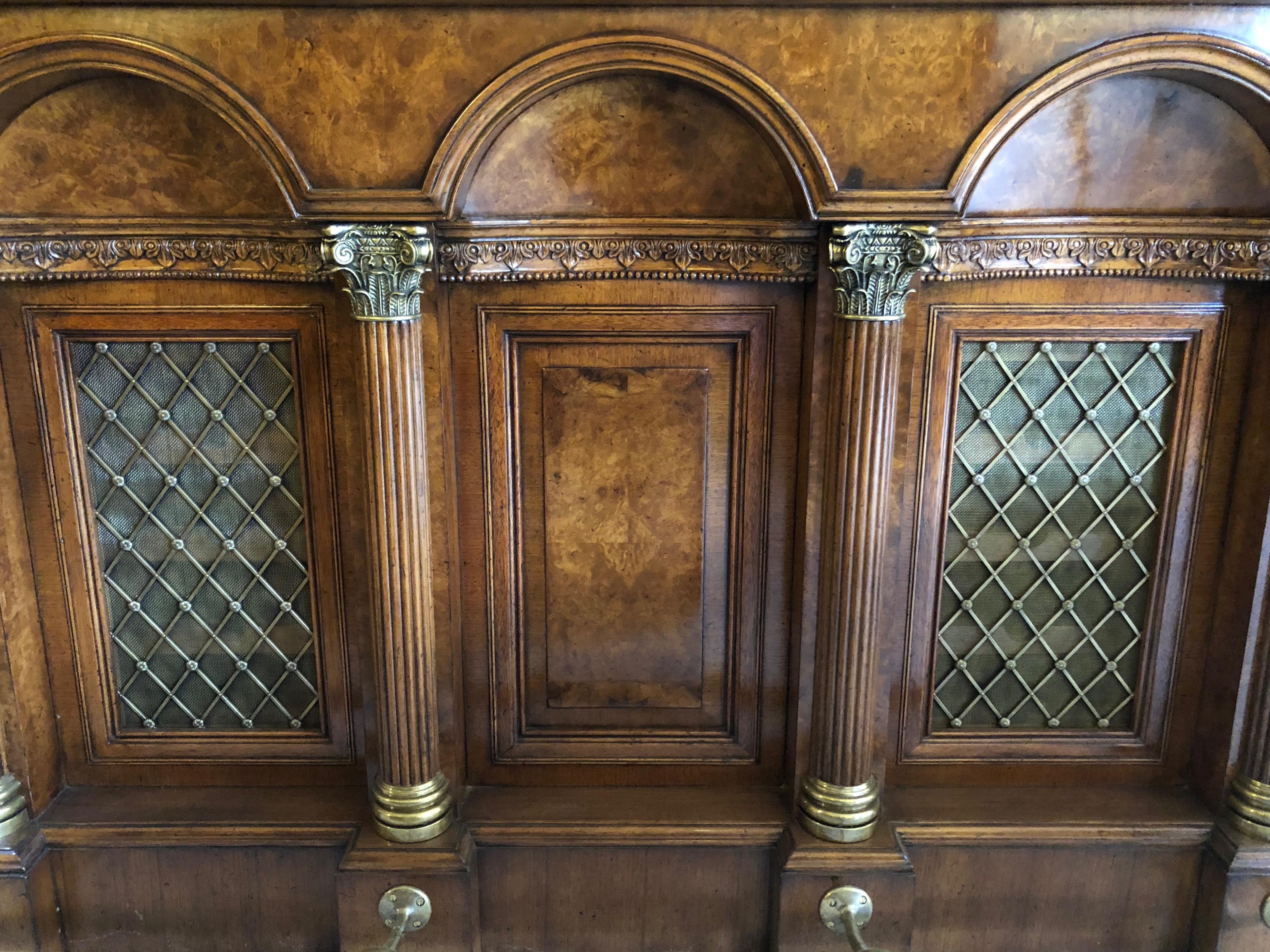 Antique design burr walnut bar, superb quality.
With Breccia marble-top, Greek key frieze, three arched panels, two with brass grilles flanked by Corinthian columns, the base with a brass foot rail. The front grilles fitted with lighting.
The