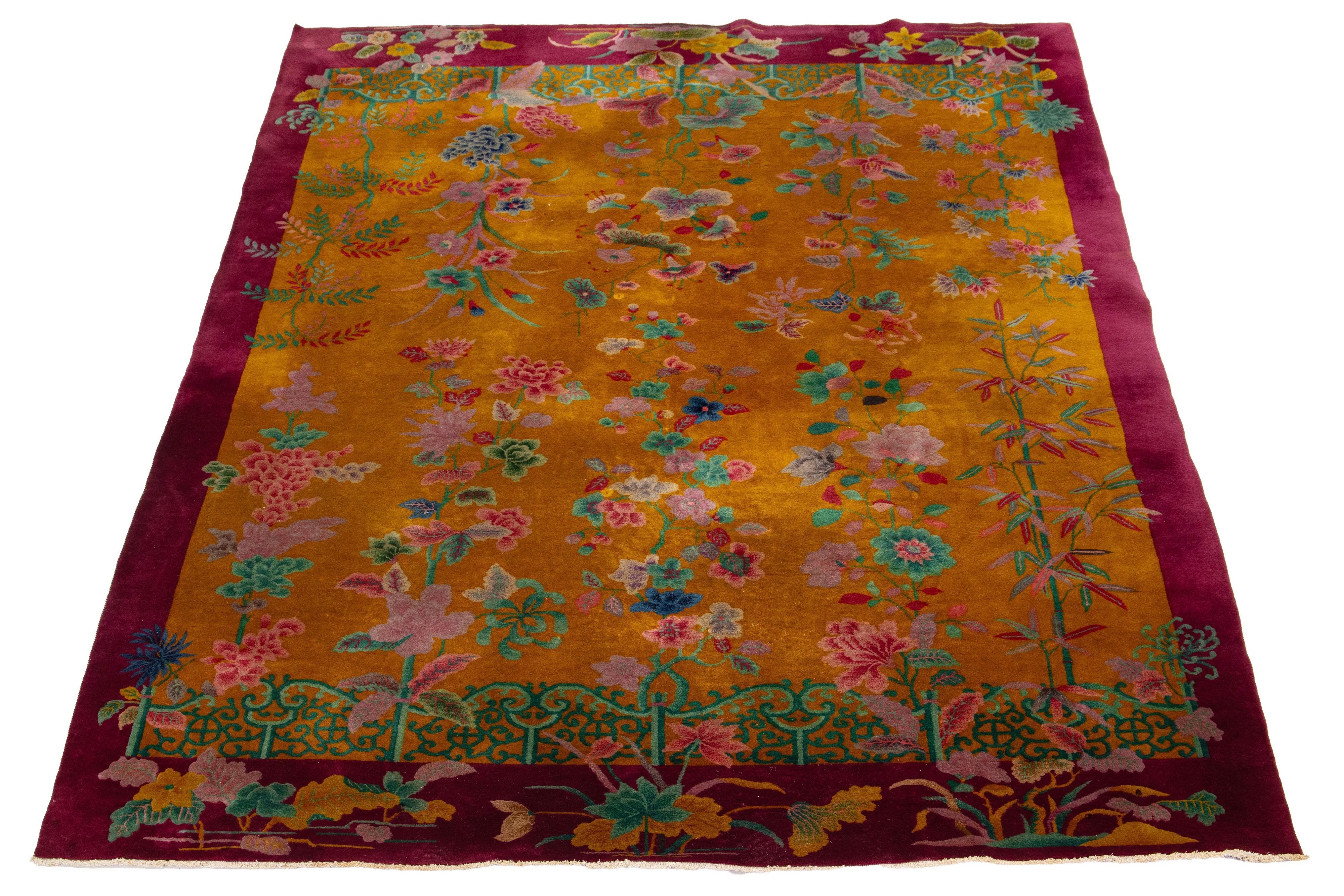 This elegant antique Art Deco Chinese wool rug features a goldenrod-colored field with a burgundy-colored decorative border and vibrant accents, showcasing a stunning classic Chinese floral motif.

This rug measures 8'9 x 11'6
