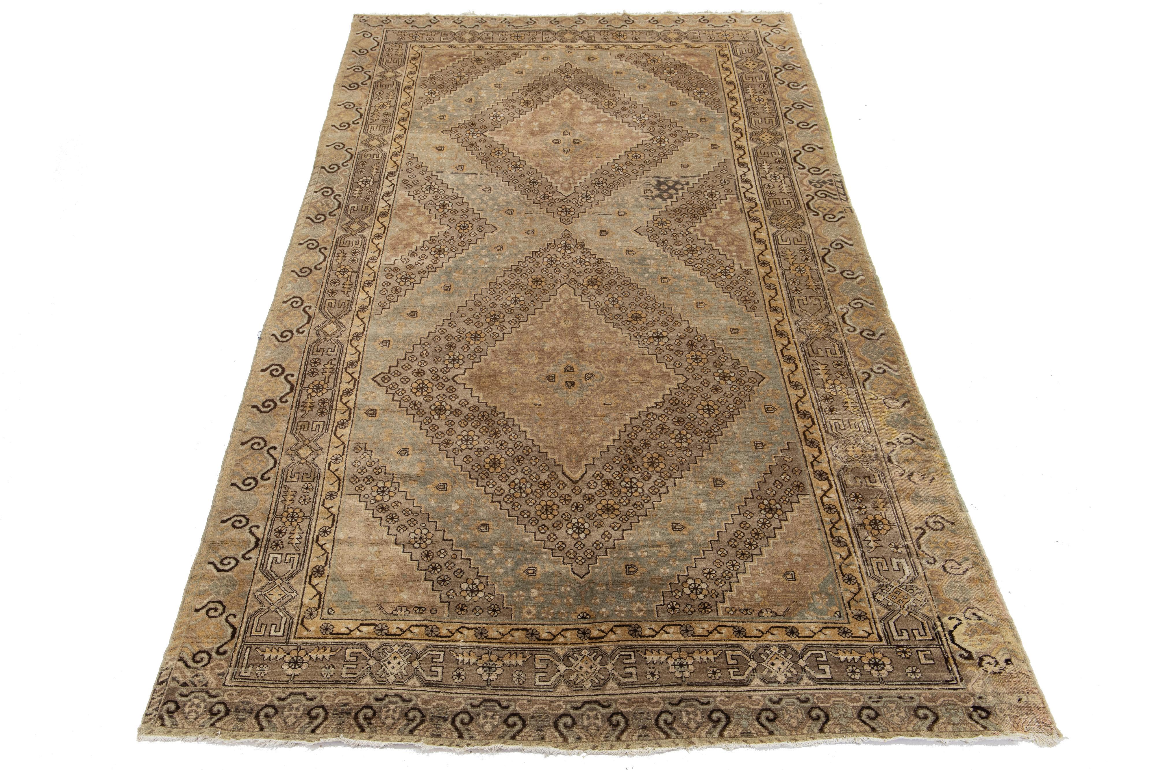 Bellissimo tappeto antico turco Khotan in lana annodato a mano con campo marrone chiaro. Questo Khotan presenta accenti grigio-blu e beige in uno splendido motivo tribale all-over.

Questo runner misura 6'7
