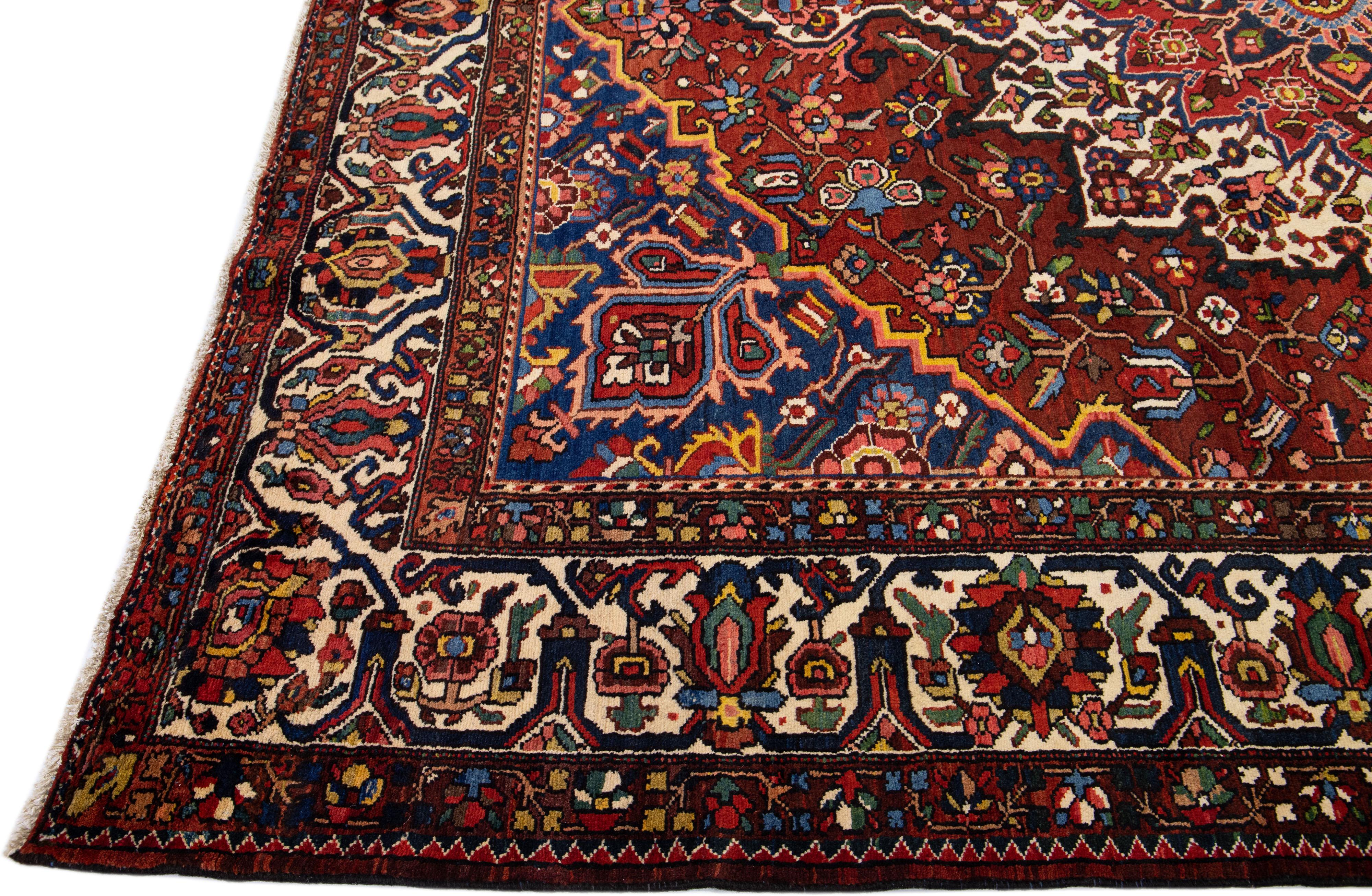 Beautiful Antique Bakhtiari hand-knotted wool rug with a red field. This Persian piece has an all-over multicolor accent in a gorgeous classic rosette Medallion motif.

This rug measures 10'9