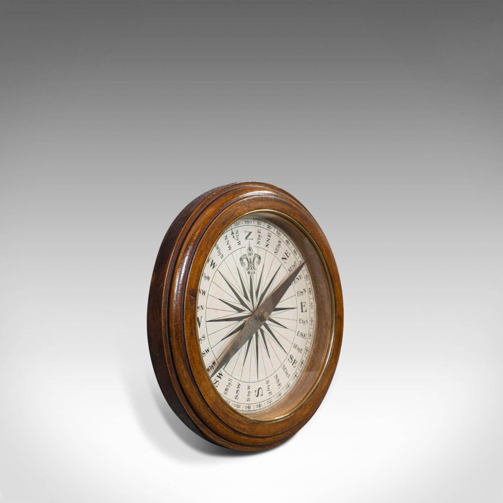 This is an antique desk compass. An English, oak maritime or ship's compass and dating to the Regency period, circa 1830.

Of fine form and bright, legible, sun-burst face - diameter of 17.5cm (7