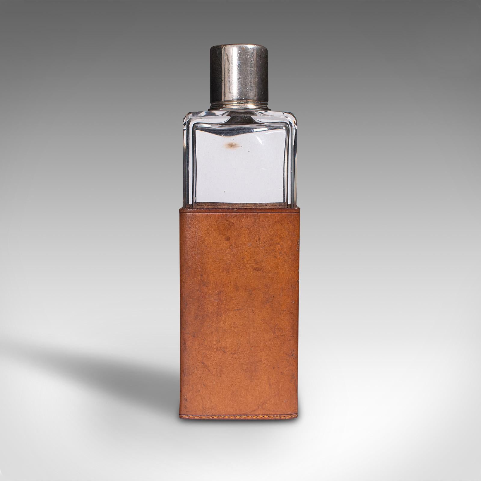 This is an antique desk flask. An English, glass and leather cased drinking bottle, dating to the Edwardian period, circa 1910.

Dashing flask replete with quality glass and leather sleeve
Displays a desirable aged patina and in good