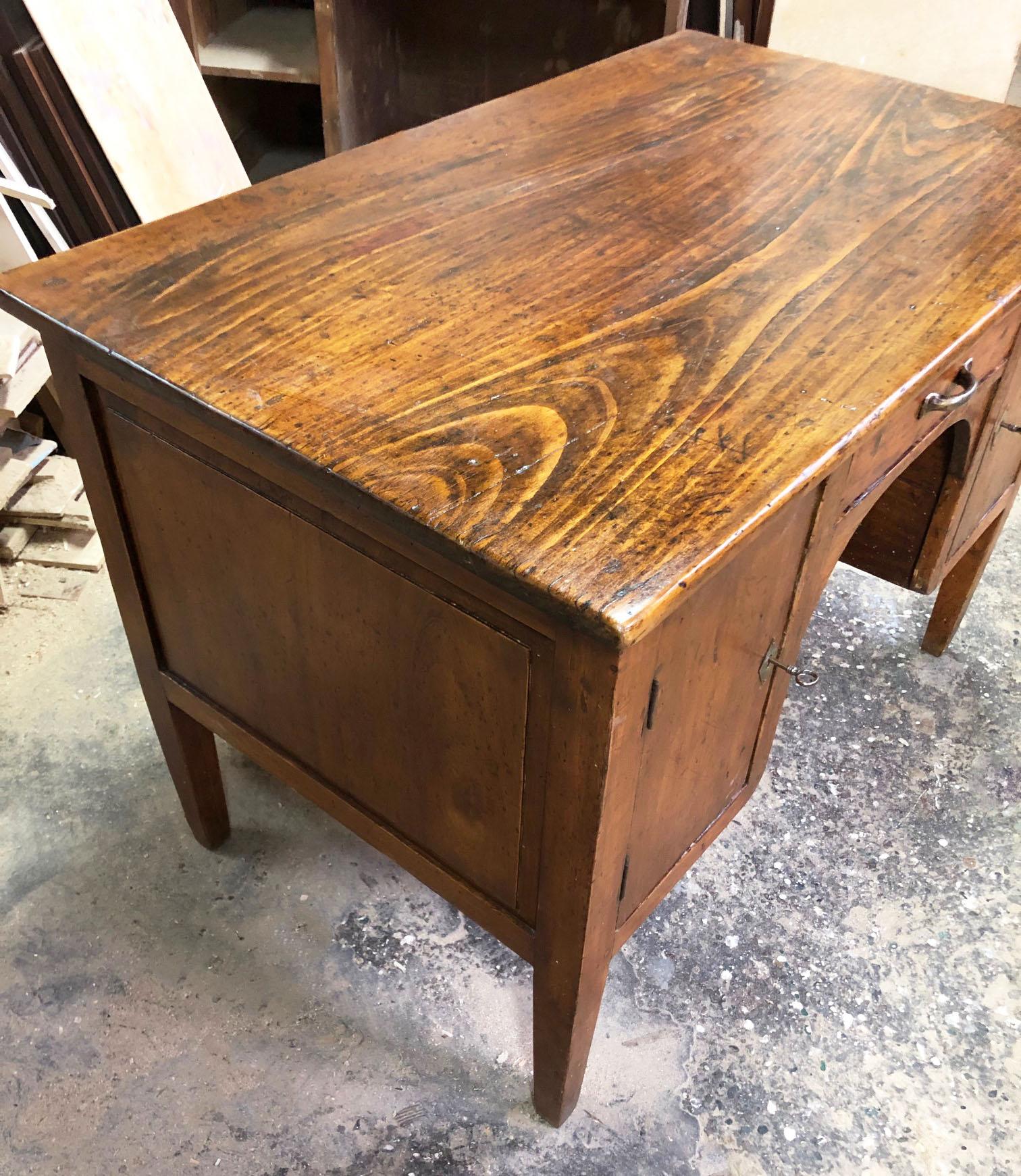 Antique desk, original Italian 20th.  in poplar, with a central drawer and two side doors.
Original honey color, very well maintained.
It is sturdy and heavy.
The desk is very practical, it will be your comfortable office.
Comes from an old country