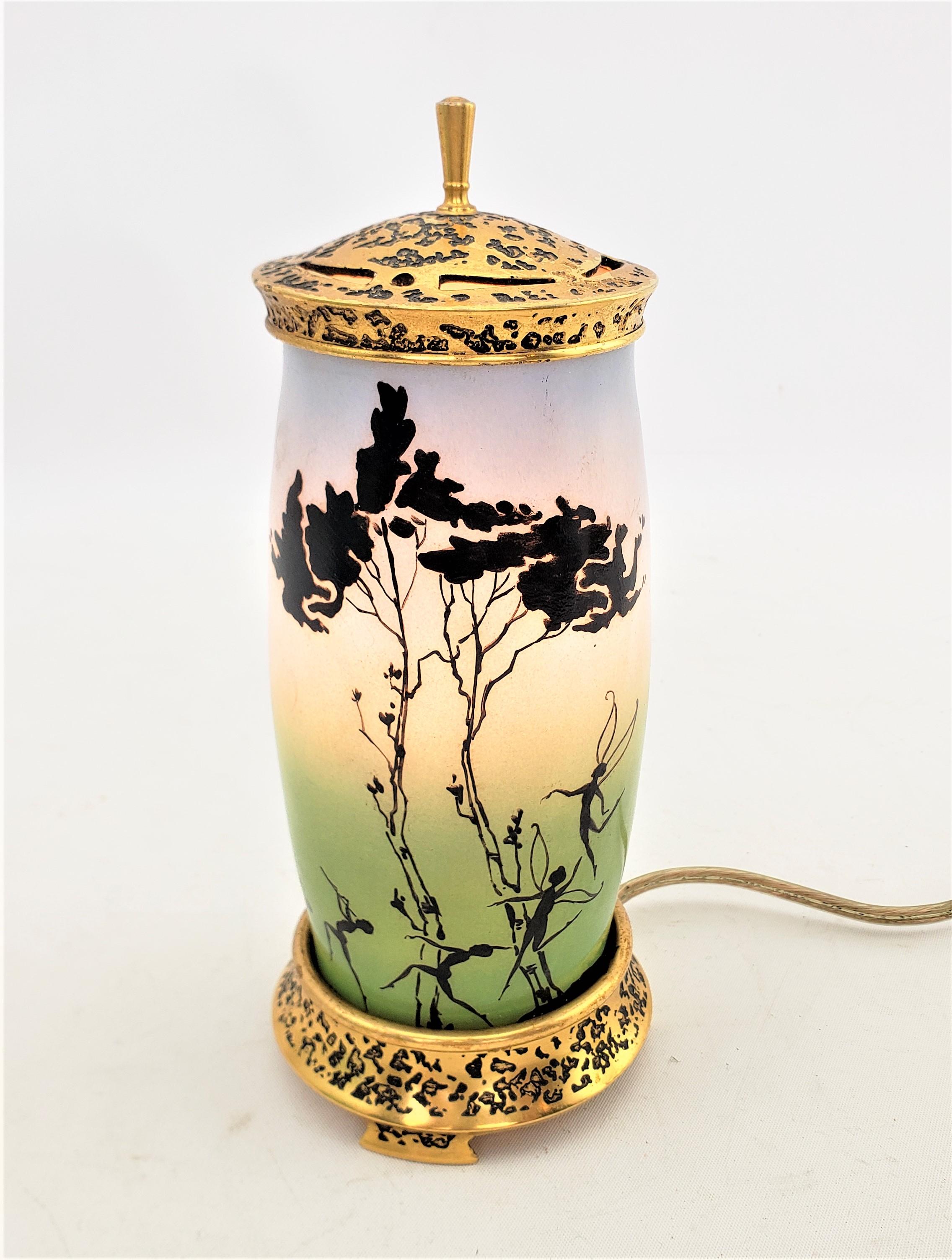 This perfume lamp was made by the well known Devilbiss company of the United States, and assembled in Canada and dates to approximately 1920 and done in the period Art Deco style. The lamp is composed of a gilt bronze top and base with etched and