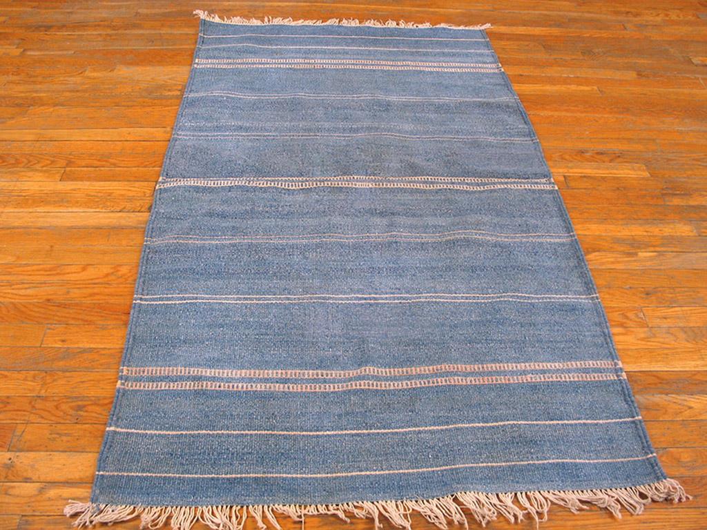 This vintage, miniature Dhurrie is a study in light blue, ever-abrashing sublty, with delicate off-white linear accents. Total minimalism with no border. In the denim blue stripes are barely visible bands of a slightly lighter blue. Good condition