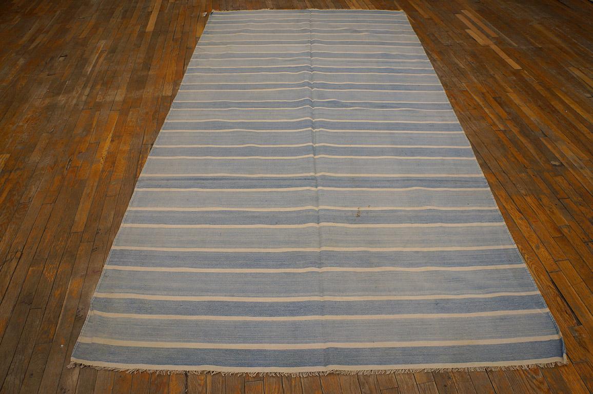 There must be 10,000 shades of Dhurrie blue and this long rug (kellegi) format piece shows a light pattern of un-bordered stripes in sky and light blue, with narrow eggshell lines between. A short step to a narrow(er) runner. Virtually antique, good