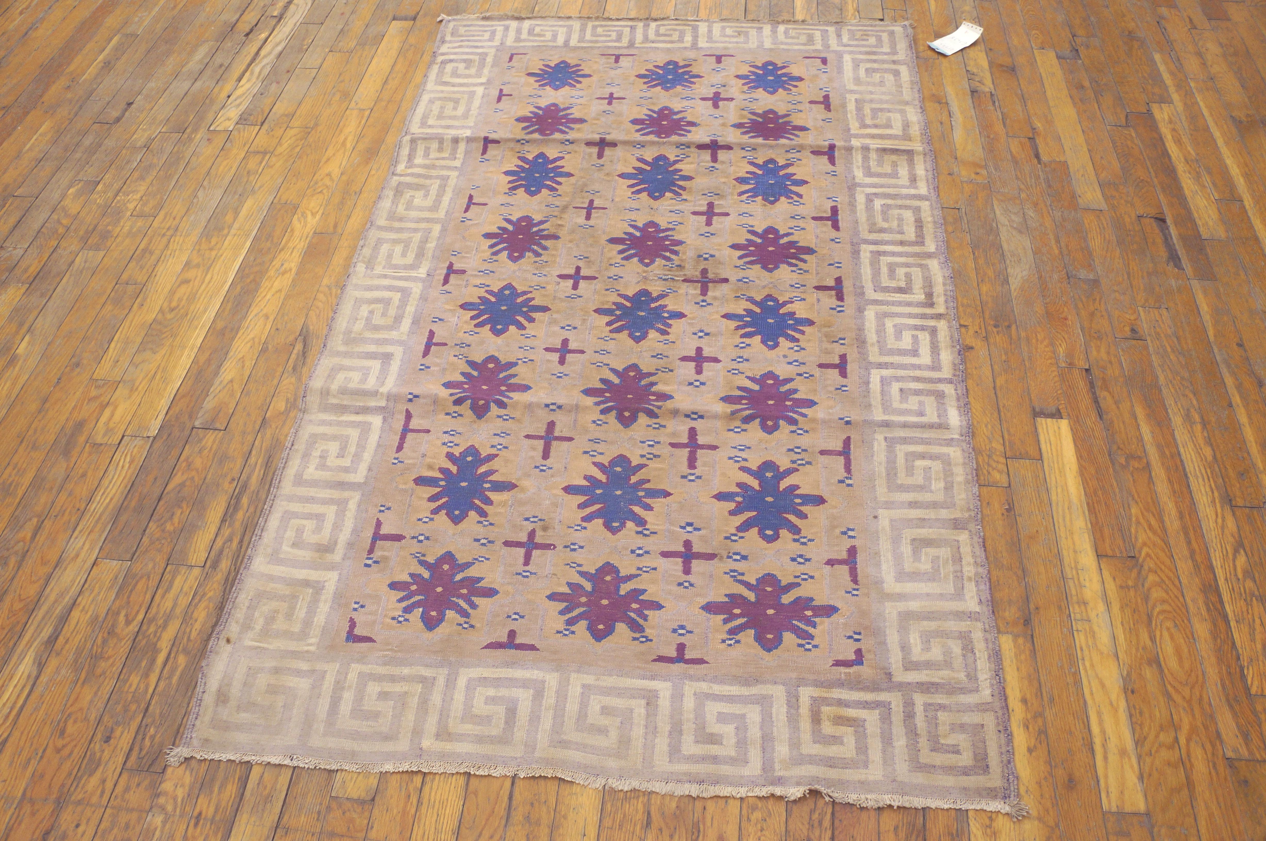 The tan-gold field displays a three column quasi-Turkmen gul design delineated in medium blue with lesser cruciform minor guls. Beige and tan square wave border. Good condition. Unusual example of design admixture. Antique example.