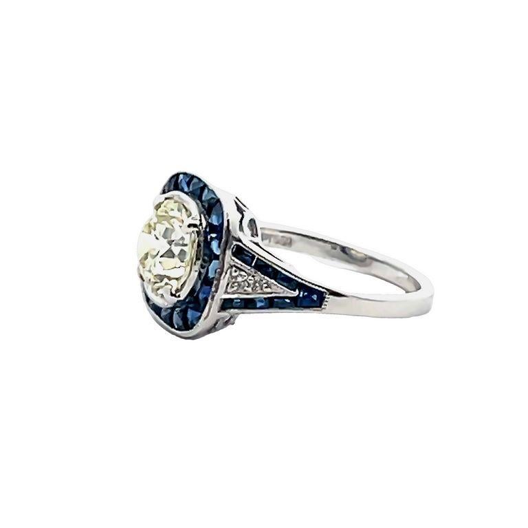 Introducing our stunning and elegant ring, featuring a breathtaking round diamond in the center with a total of 1.48 carats. This diamond is surrounded by a halo of beautiful blue sapphires, you can also appreciate these blue sapphires in the shank