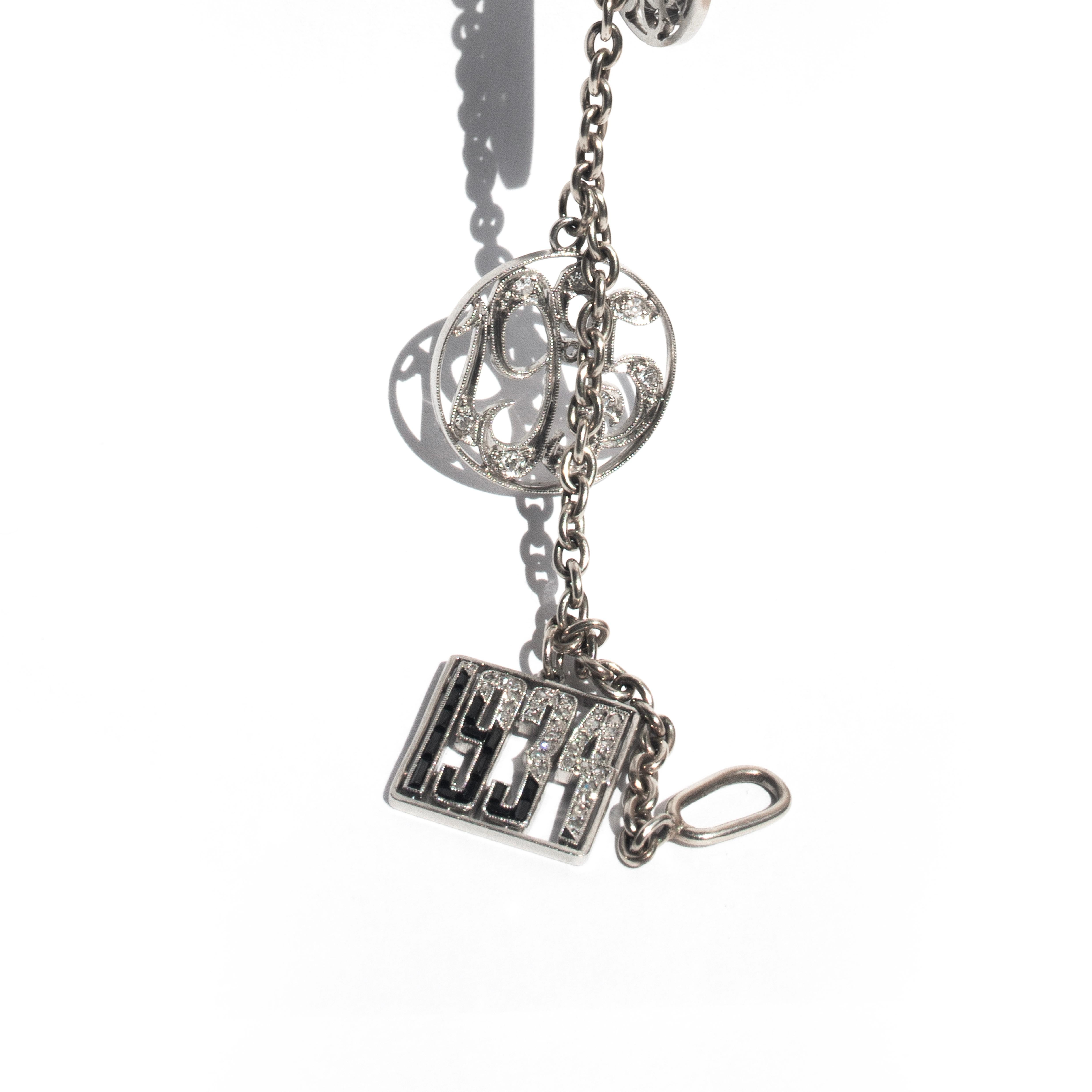 Introducing an original antique 14 carat white gold bracelet that can be a true treasure with special meaning for you or a loved one, thanks to the wonderful platinum charms that suspend gracefully from an elegant cable chain.

The fantastic