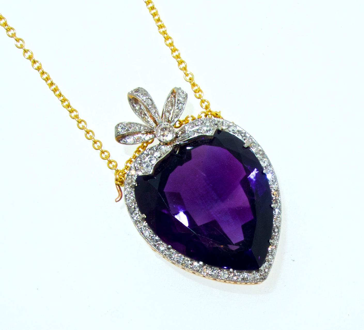 The center deep violet purple amethyst is from the Siberian area of Russian, it weighs 20 cts., approximately.  This center heart shaped stone is surrounded and accented by 80 old cut white diamonds.  This pin/pendant is suspended on a modern 5 ct.,