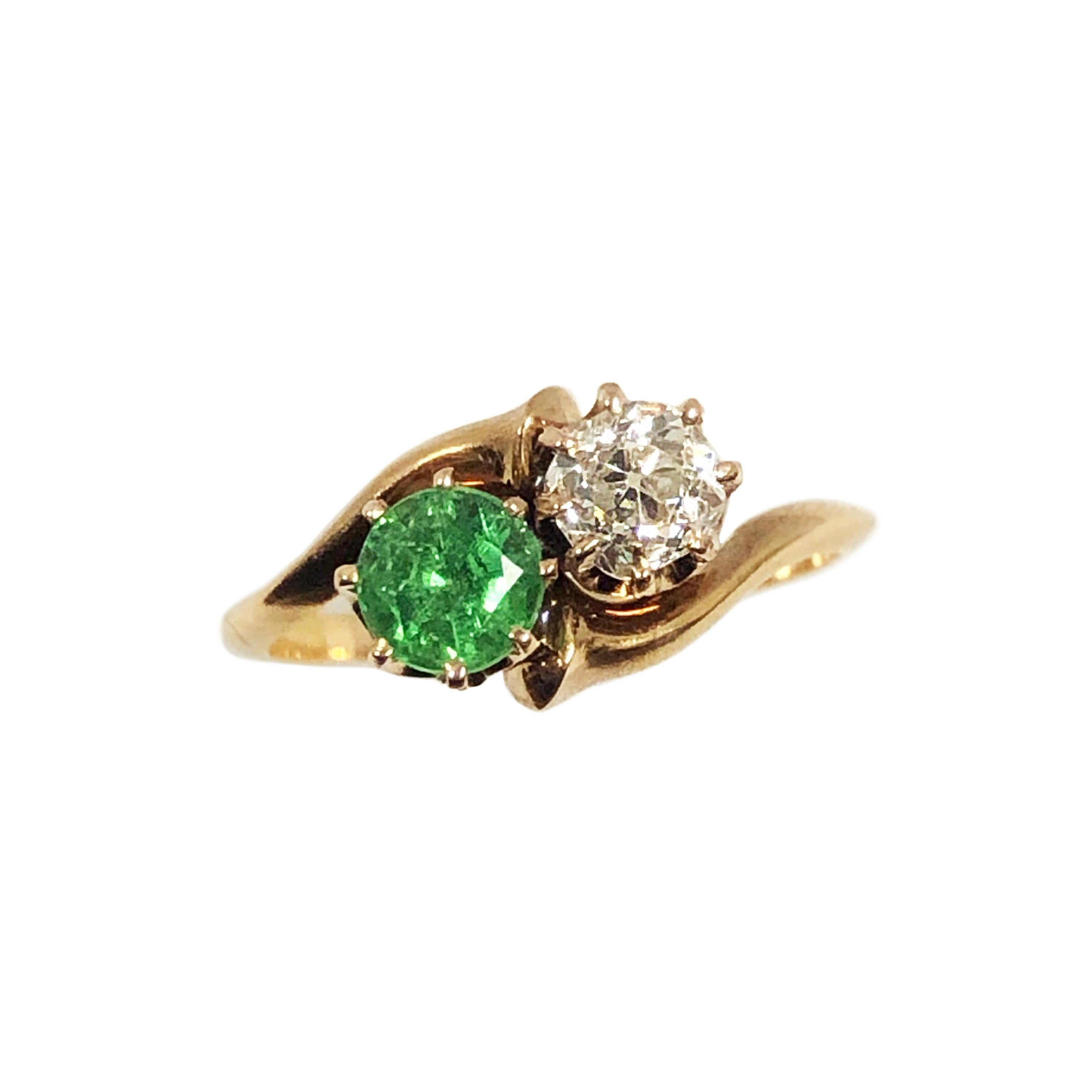 Circa 1900 14k Yellow Gold Btpass Ring set with an old Mine Cut Diamond of approximately .60 Carat and Grading as H in color and VS in Clarity, further set with a Green Demantoid Garnet of a Good intense Color typical of Russian, Ural Mountain mined