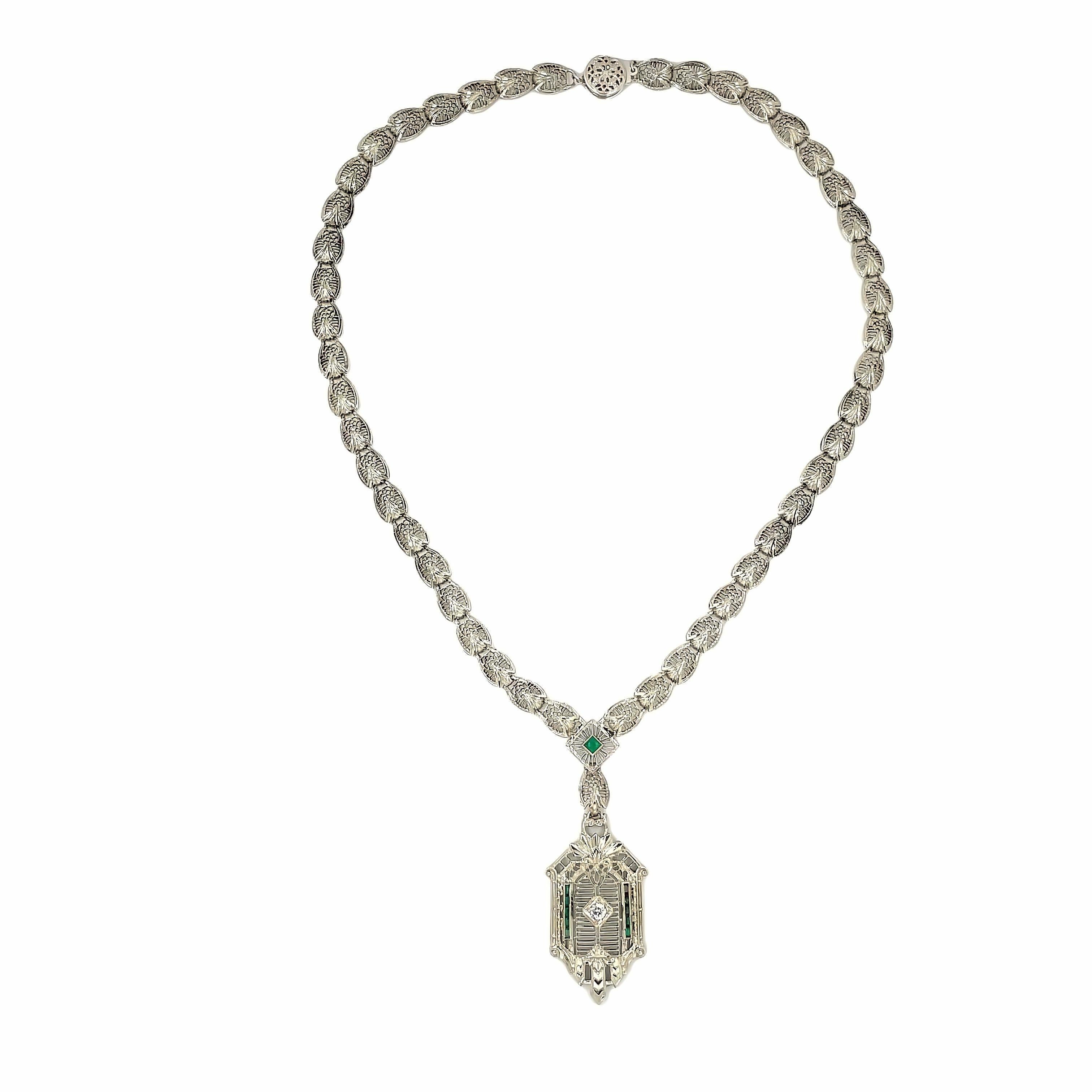 This magnificent necklace is an exquisite piece of art, combining intricate filigree work, natural emeralds, and an old European cut diamond in the center. The necklace is crafted in 14k white gold, and the filigree work is stunningly ethereal,