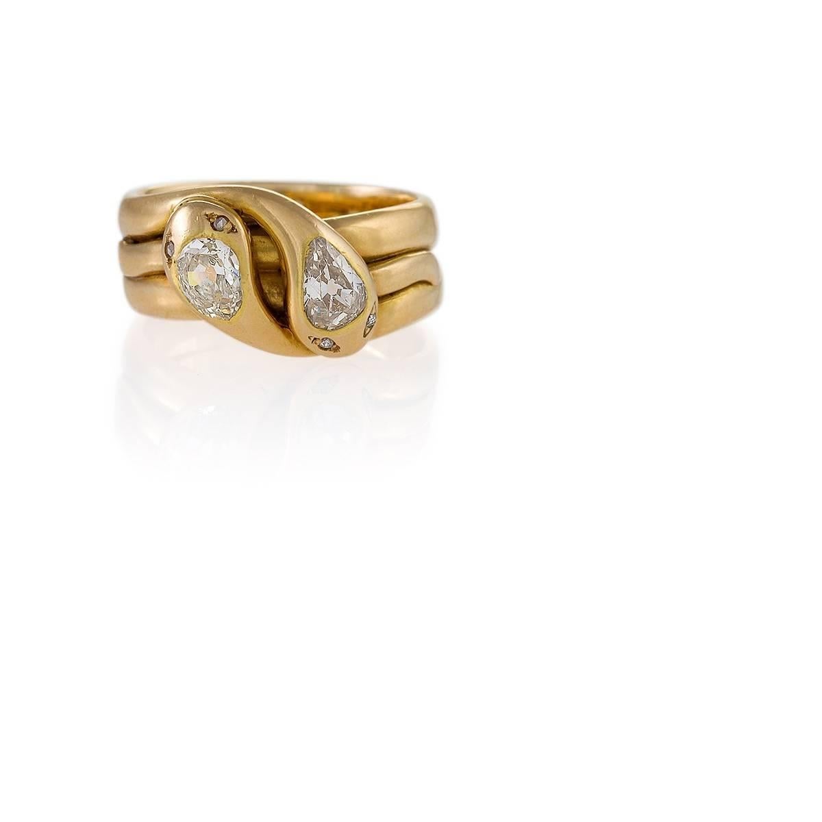 An Antique 18 karat gold double serpent ring with diamonds. The ring has a 2 old European-cut pear diamonds with an approximate total weight of 1.00 carat, and 4 rose-cut diamonds with an approximate total weight of .04 carat. The ring is designed