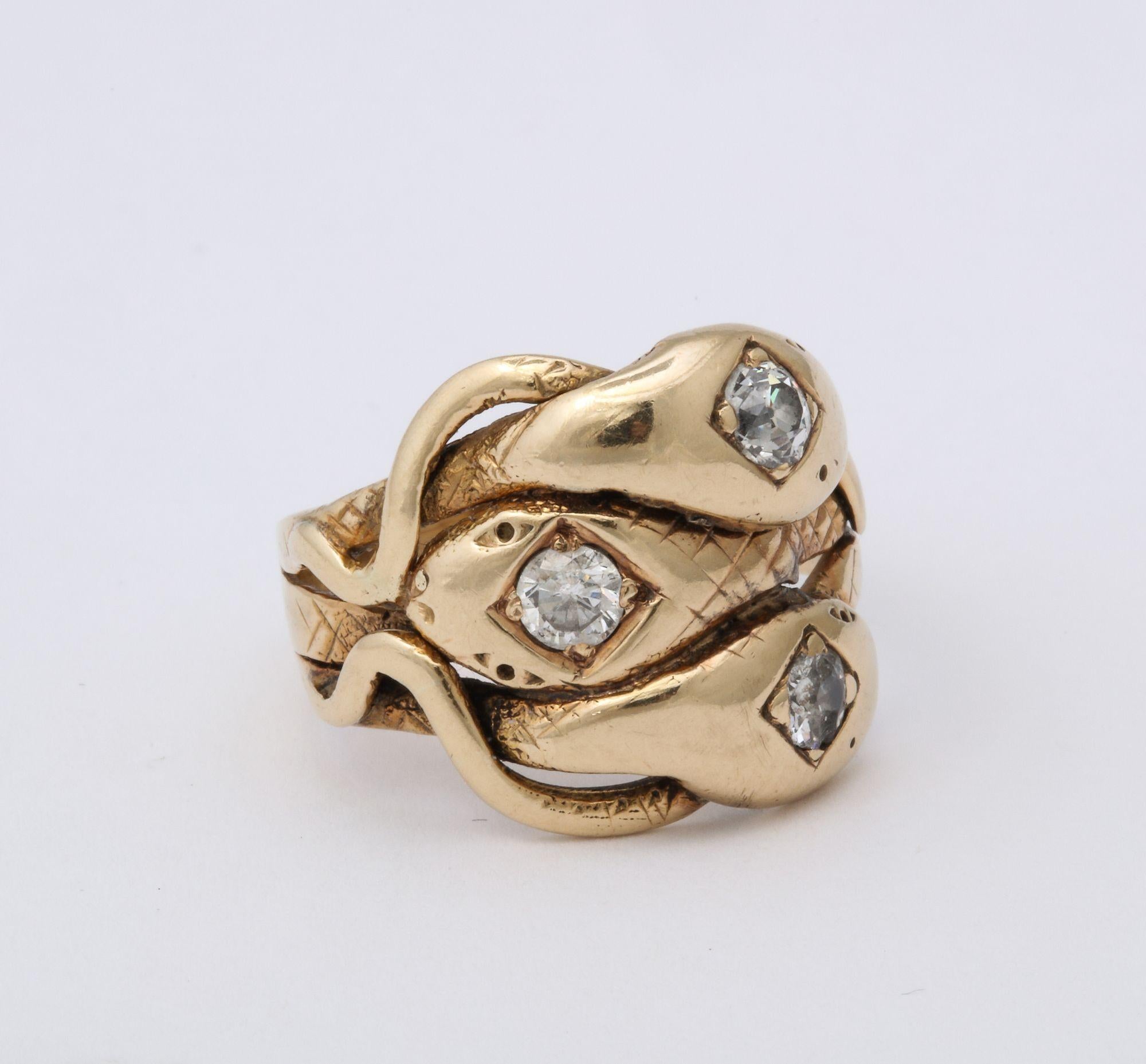 A unique Antique Diamond and Gold Three Headed Snake Ring. Three intertwined snakes with Old European cut diamonds inset into the heads wrap around the finger. A rare ring that is a real find.