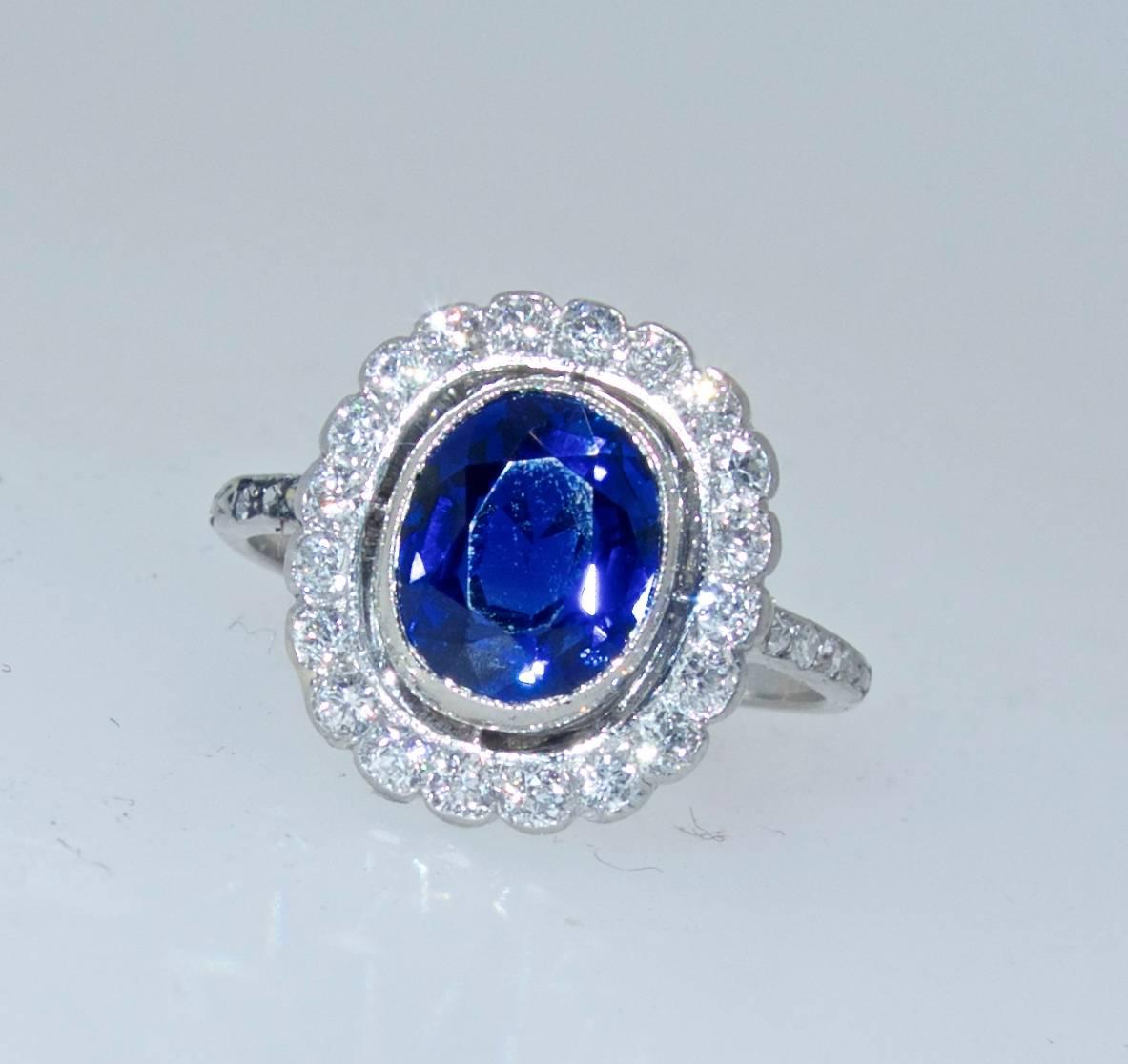  Natural unheated sapphire weighing 2.32 cts and displaying a bright blue.  This platinum ring also has .60 cts of old European cut diamonds which surround this lovely sapphire.  Circa 1915.