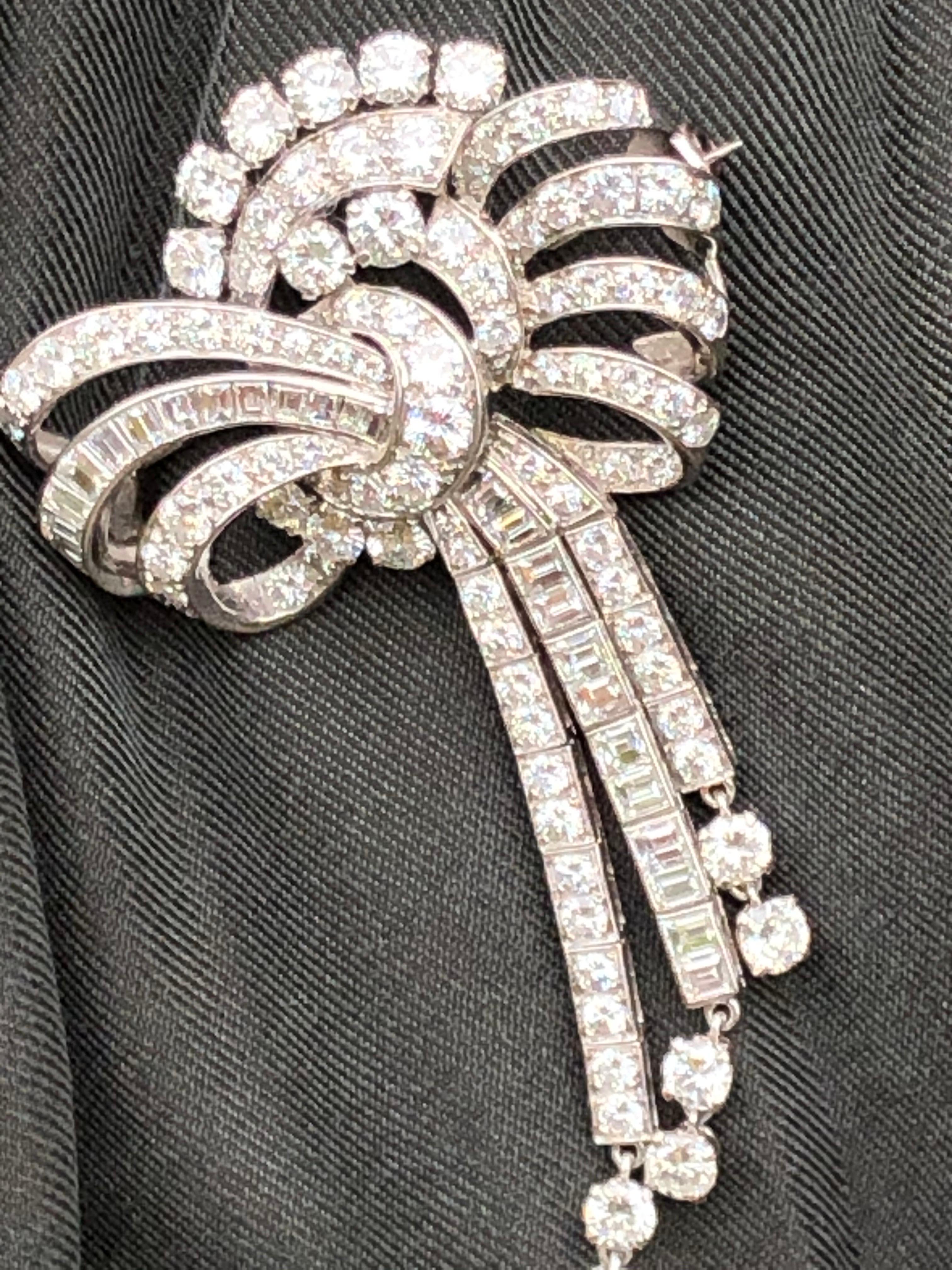 The pictures of this brooch do not o it justice! The diamonds are so bright and the mix of baguette and round brilliant cut diamonds make this piece even more beautiful! The bow detail and the tails that hang down have free hanging pendants holding