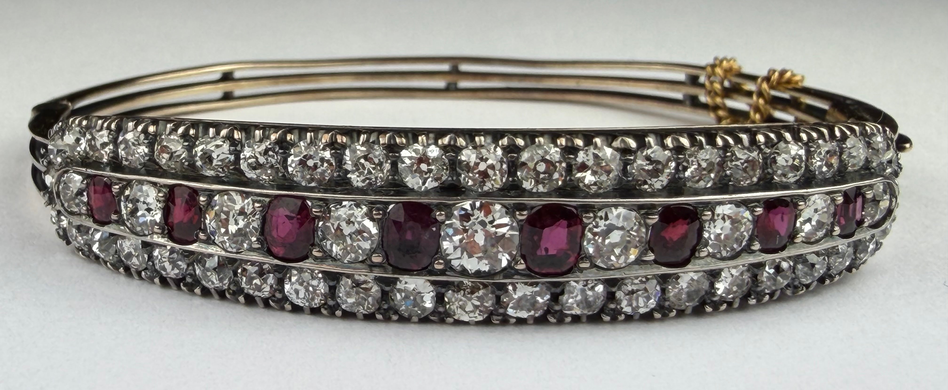 This glamorous late Edwardian/early Art Deco bangle bracelet features eight oval shaped natural red rubies totaling approximately 2.00 carats and fifty-three sparkling Old European-cut diamonds totaling approximately 4.00 carats, H-I color VS-I1