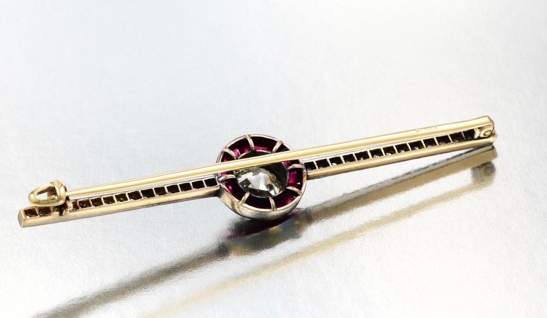Crafted in silver on 14K gold, featuring an old European-cut diamond weighing approximately 1.05 carats, 

I-J-K color and SI-I clarity

surrounded by 16 square-cut rubies weighing a total of approximately 0.55 carat

further enhanced by 28