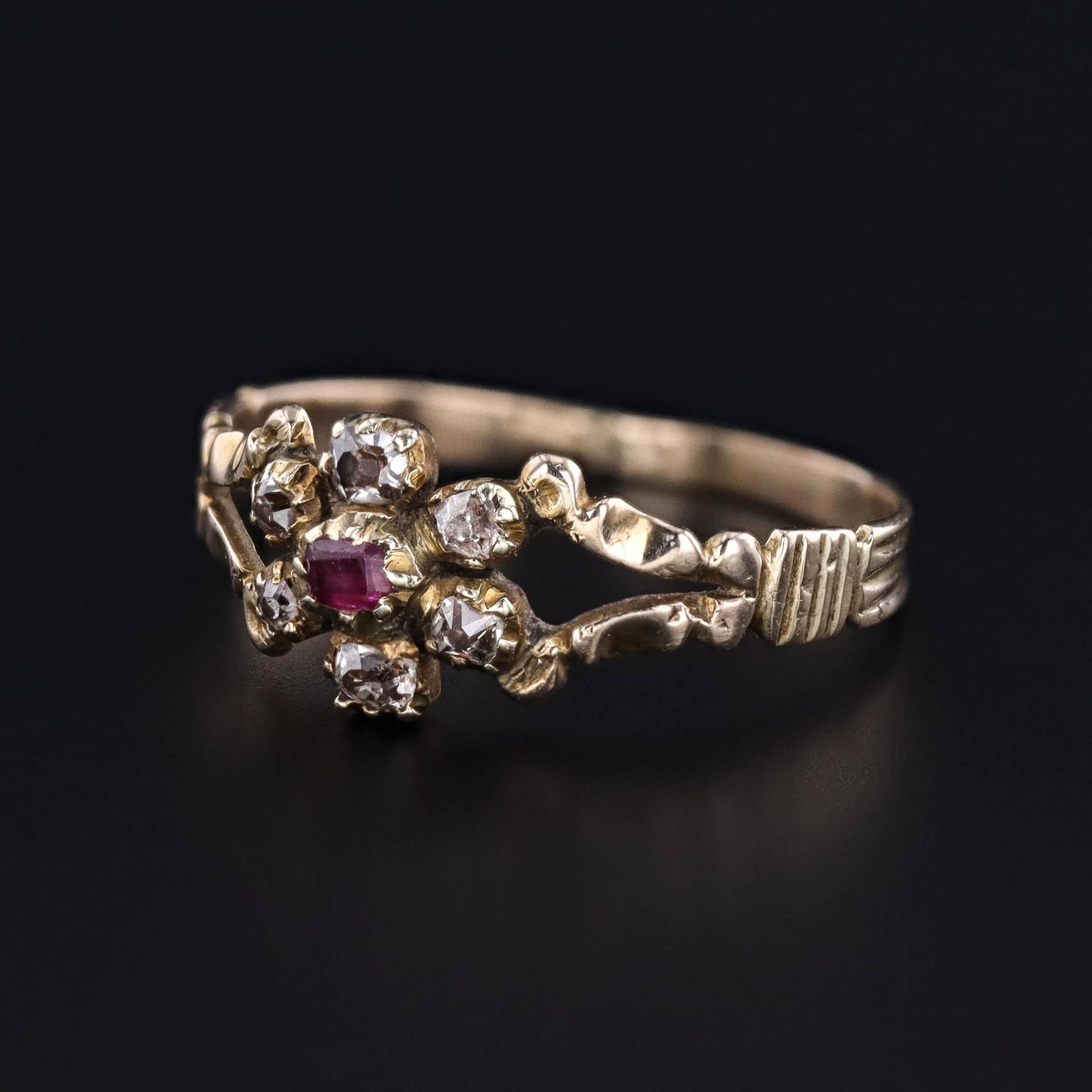 An antique ring (circa 1830-1840) featuring a ruby and diamond flower on a 12ct gold band.

The face of the ring measures 0.3 inches from north to south, and it is in great condition. The ring is a size 6 but can be resized for an additional