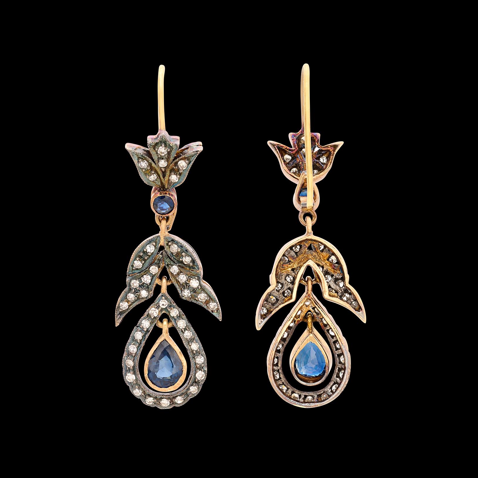 These elegant silver-topped 18k gold drop earrings bring the past to the present. With 2.20 carats of bezel-set round and pear-shaped sapphires, brought to life with 80 single-cut diamonds weighing 0.60ct., the pendant earrings weigh 7.2 grams and