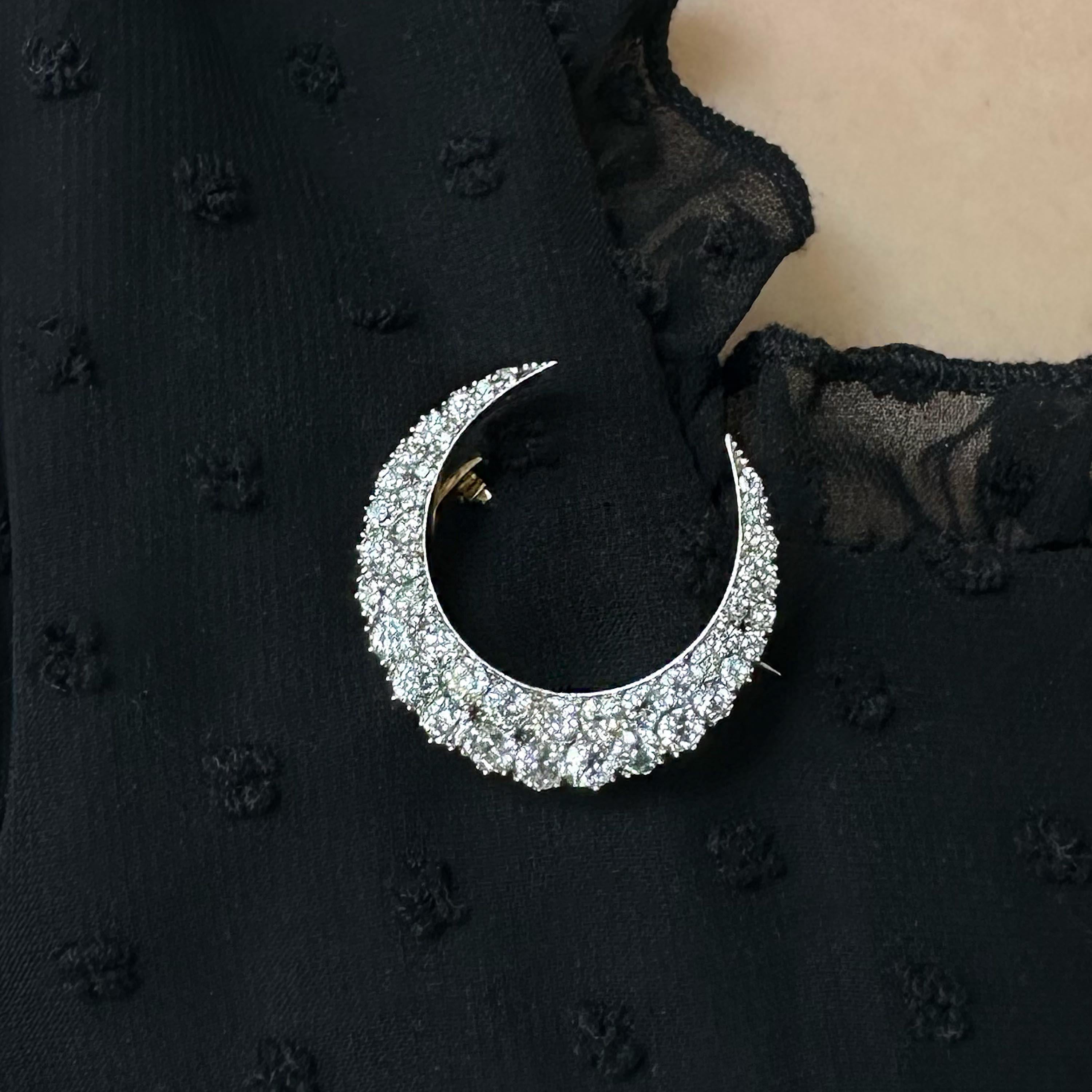 An antique crescent moon brooch, the body is set with two rows of old mine-cut diamonds, graduating in size, weighing an estimated total of 4.00 carats, grain set in silver, with a plain inner curve and cut down set outer curve, with gold gallery