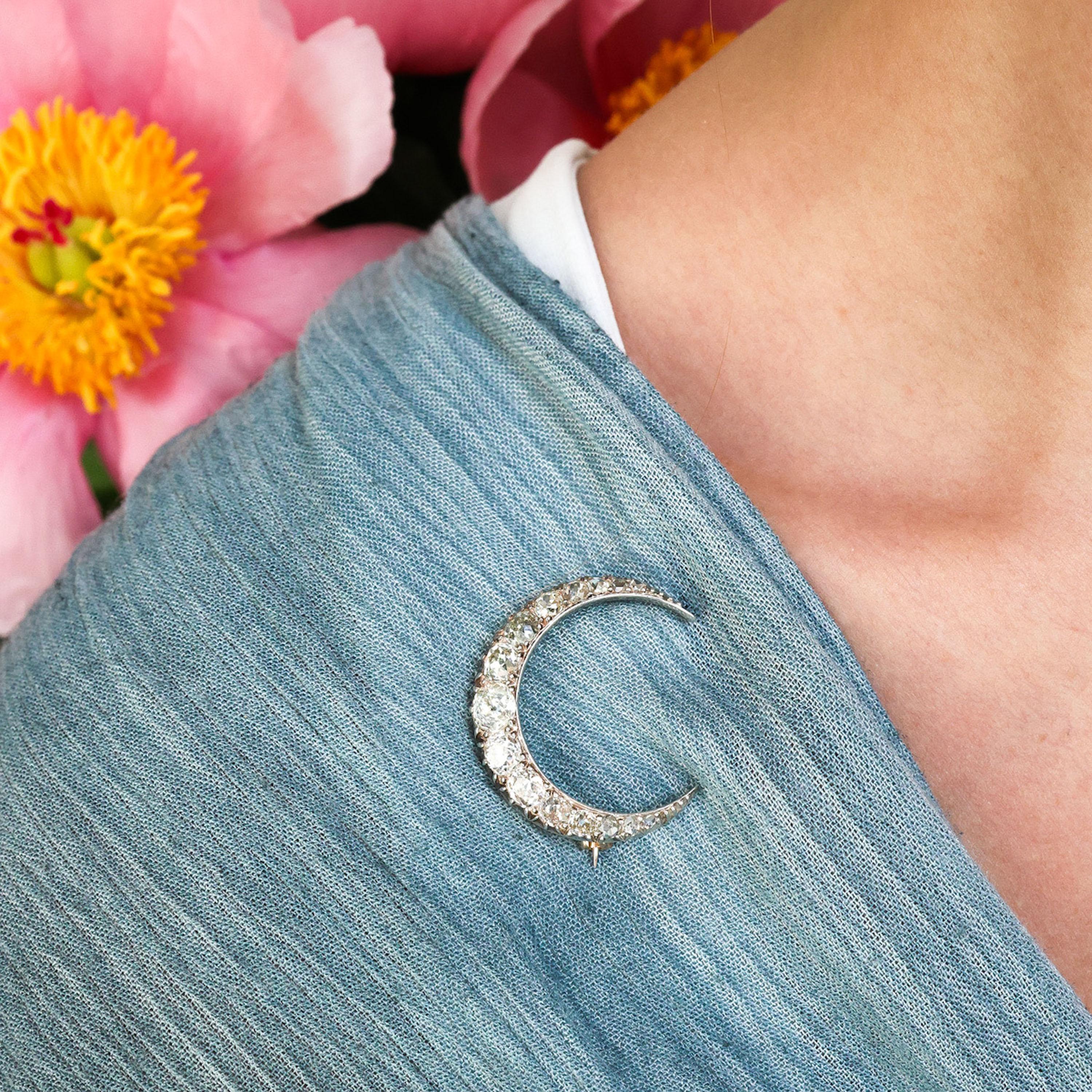 An antique crescent moon brooch, set with a single row of old-cut diamonds, graduating in size, tapering to rose-cut diamonds, weighing an estimated total of 4.00 carats, claw set in silver-upon-gold, with a plain inner curve and cut down set outer