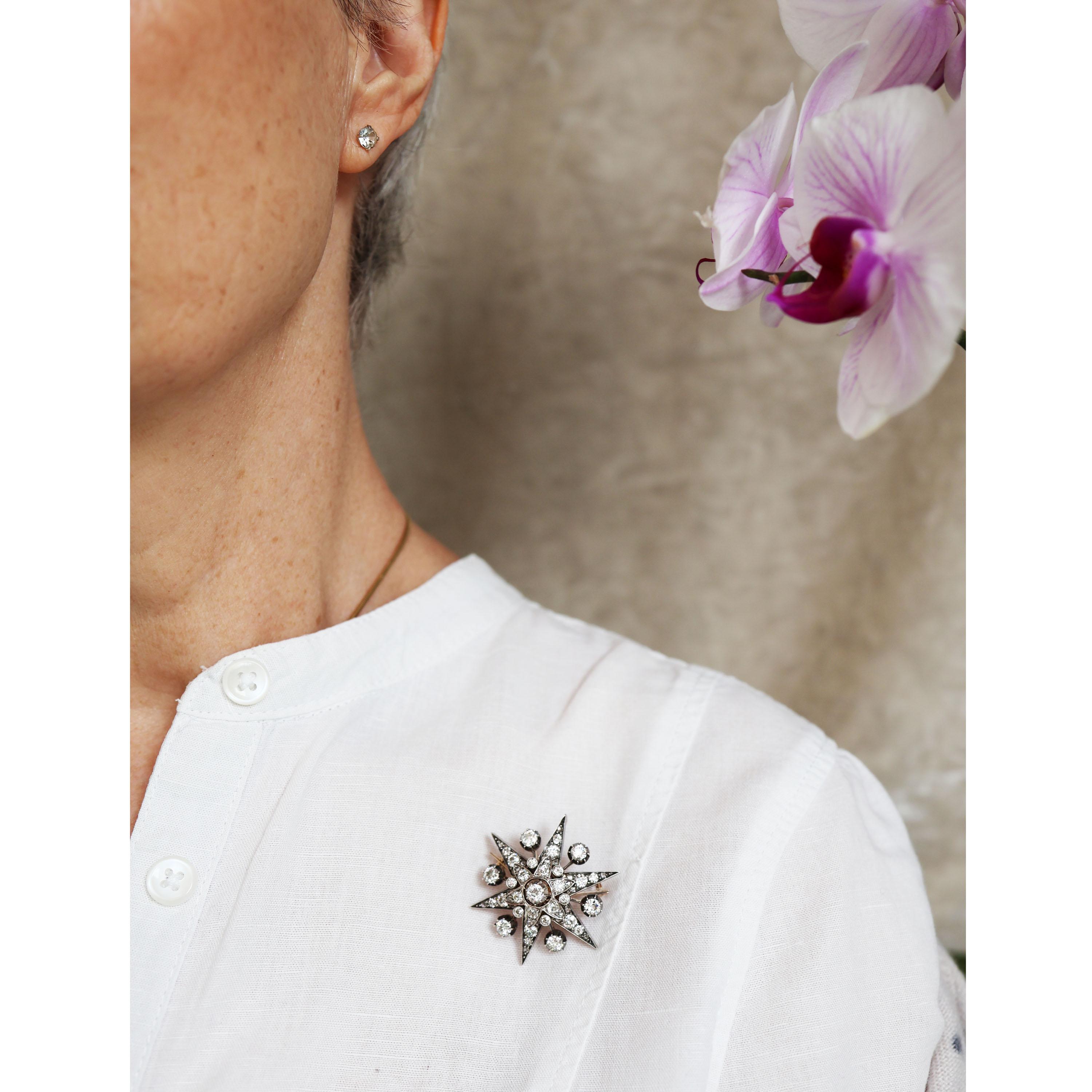 An antique diamond six point star brooch and hair pin, with rays, with an old-cut diamond, in a cut down setting, in the centre, with an air gap surrounded by a  flower, grain set with old-cut and rose-cut diamonds, with old cut diamonds in rub over