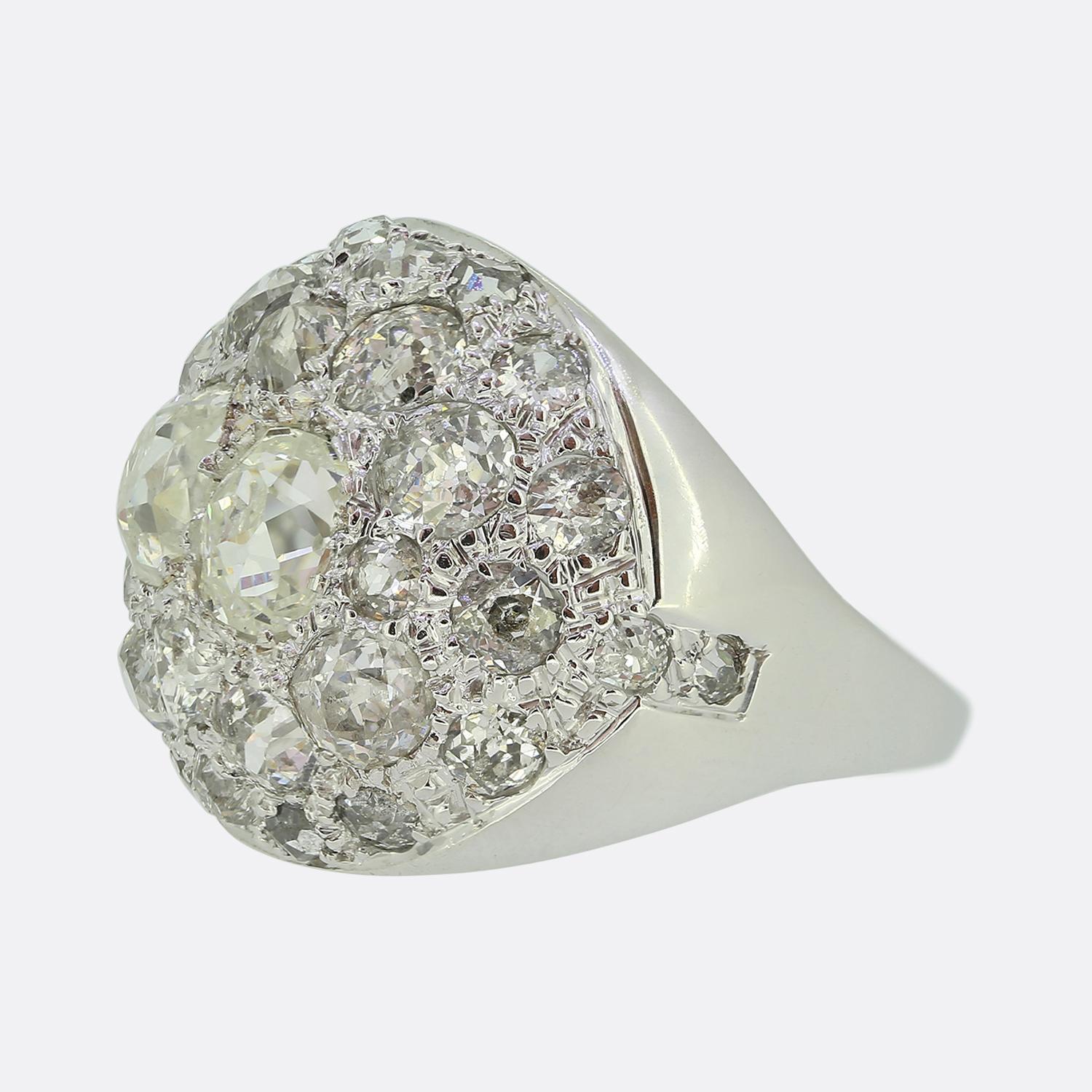 Nous avons ici une exquise bague bombe fabriquée en France en or blanc 18ct. Une tête en forme de dôme accueille deux diamants ovales facettés de taille ancienne. Ces pierres centrales focales sont ensuite accentuées par une étonnante série de