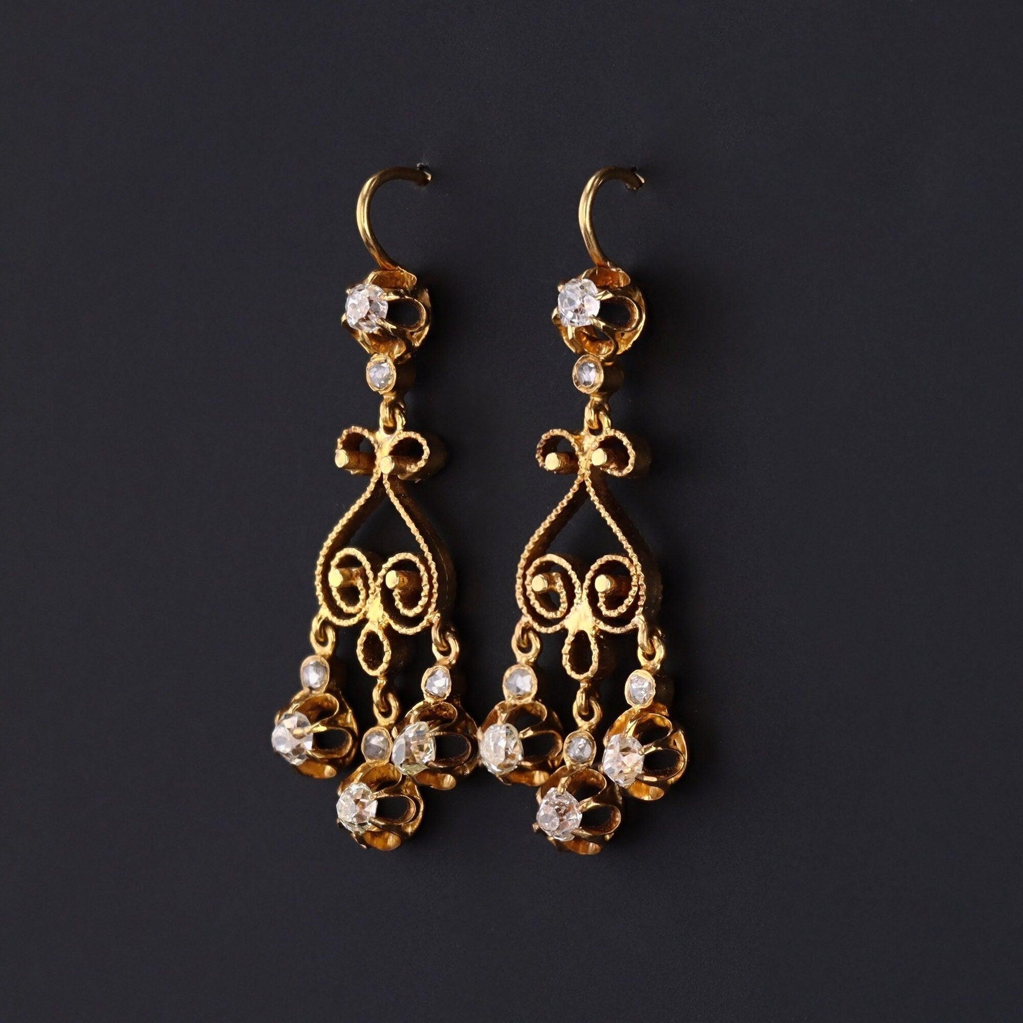 Questi ciondoli sapientemente lavorati risalgono alla fine del 1800. Presentano una cascata di quattro scintillanti diamanti taglio old mine e quattro piccoli accenti taglio rosa montati in oro 14k.

I diamanti hanno un peso totale di circa 0,56