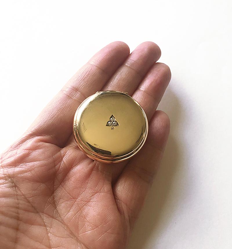 The perfect pill box.  Shiny and softly curved 14K yellow gold.  In the center are three old European cut diamonds, set in a three-leaf clover pattern.  1 1/2