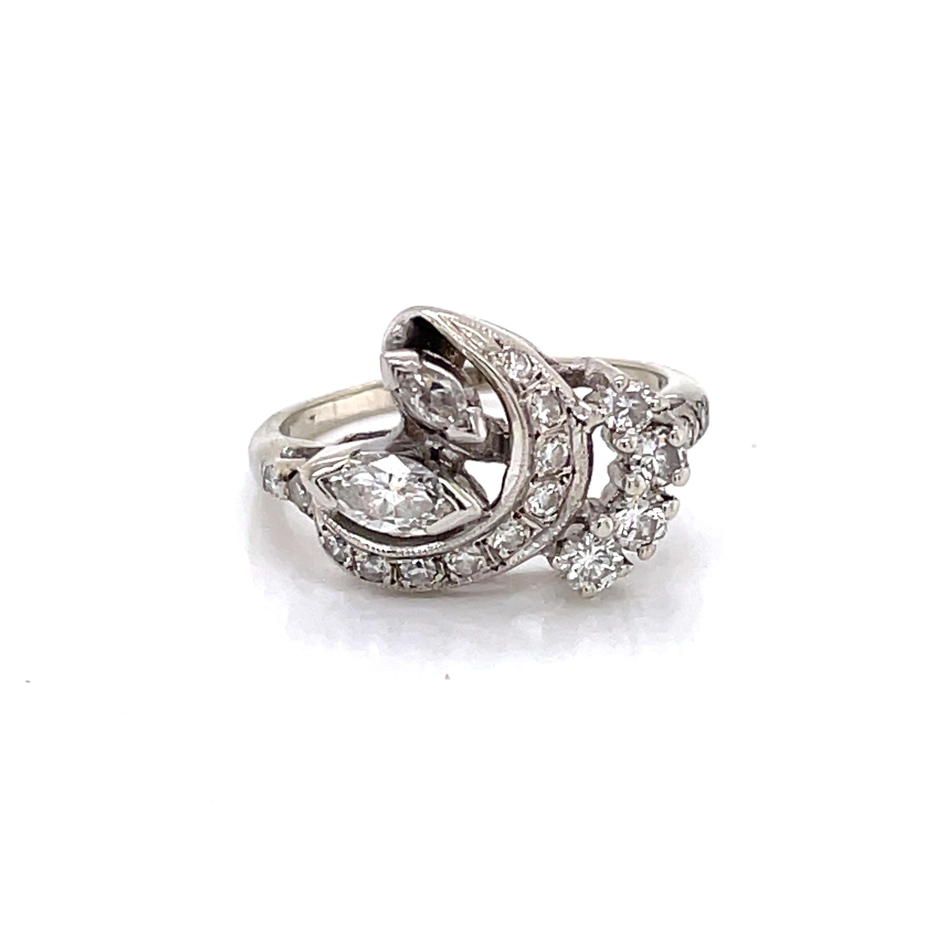 Stylish mixed diamond cuts, both marquis and round,  accent the asymmetrical design of this fourteen karat white gold 14K antique cocktail ring. With an estimated .34 total carat weight of H/VS diamonds, the curves of this ring sparkle with