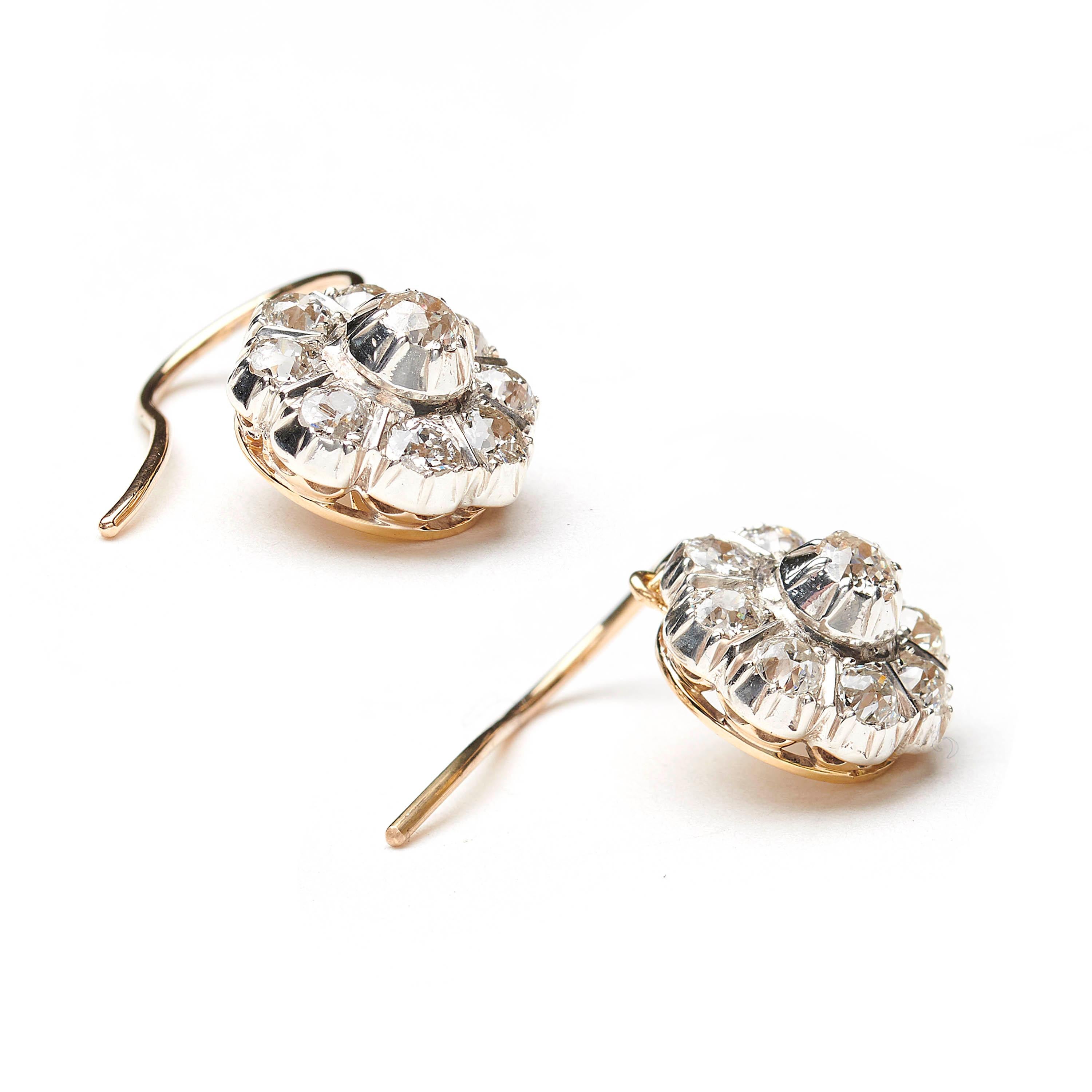 A pair of diamond drop earrings, with antique old-cut diamond clusters, with cut-down settings, mounted in silver-upon-gold, circa 1880, with new gold hook fittings, with an estimated total diamond weight of 1.60ct. In our opinion the colour is H to
