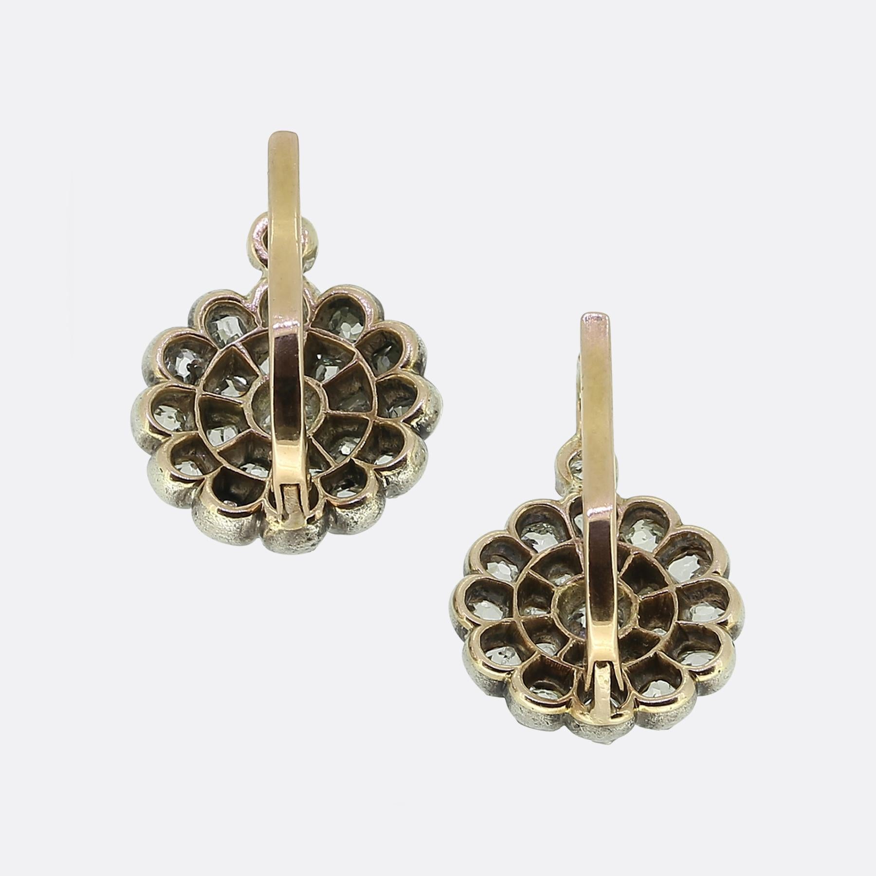 Ecco un delizioso paio di antichi orecchini a grappolo con diamanti. Ogni pezzo identico è stato realizzato in oro 18 carati e presenta una radiosa collezione di diamanti taglio old mine, ognuno dei quali è stato sapientemente incastonato