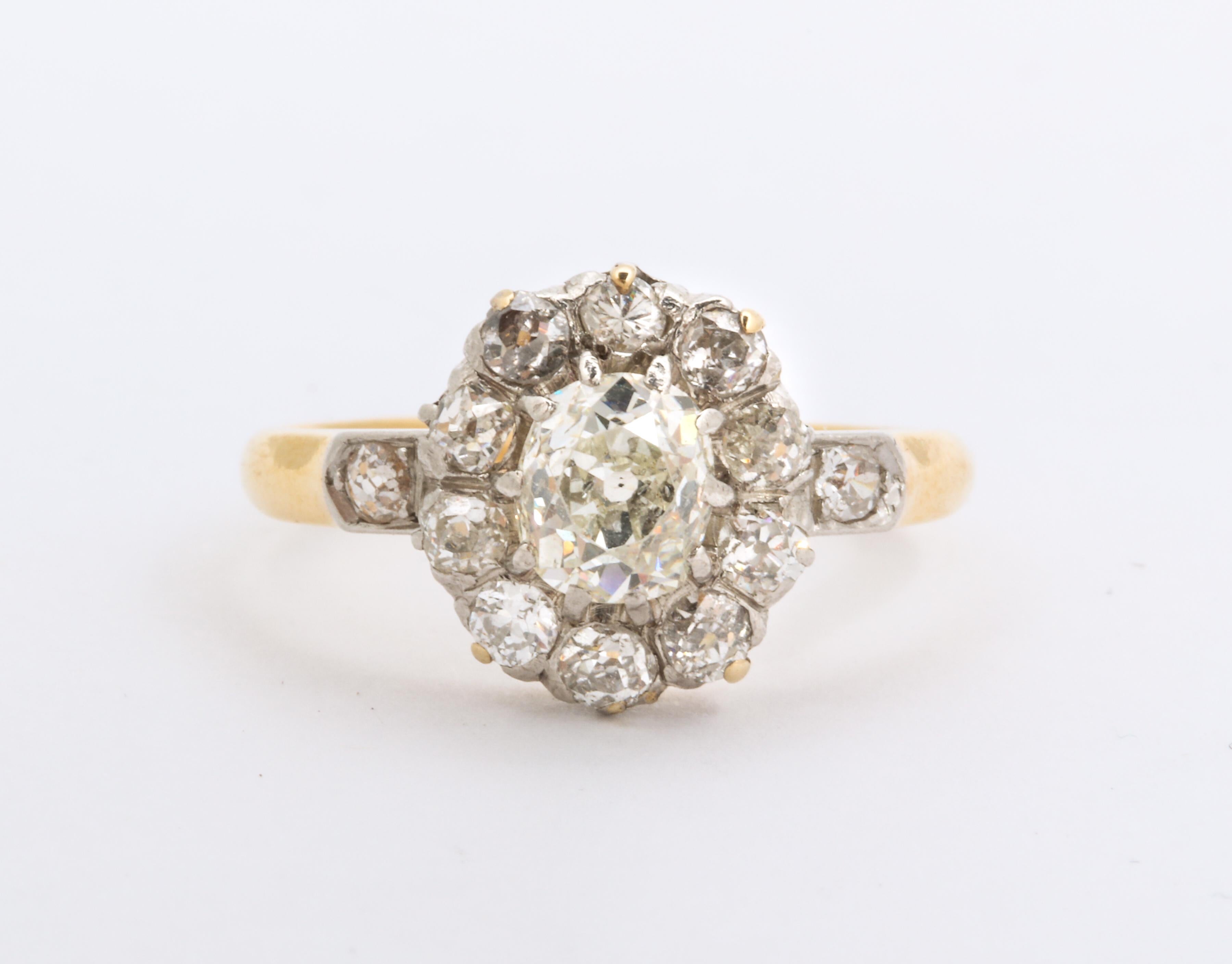 A wonderful Belle Epoch period diamond cluster gold ring. Good quality mine cut diamonds in a flower form on 18 k gold ring a prong set center is surround by individually set transitional diamonds and flanked by diamonds each side