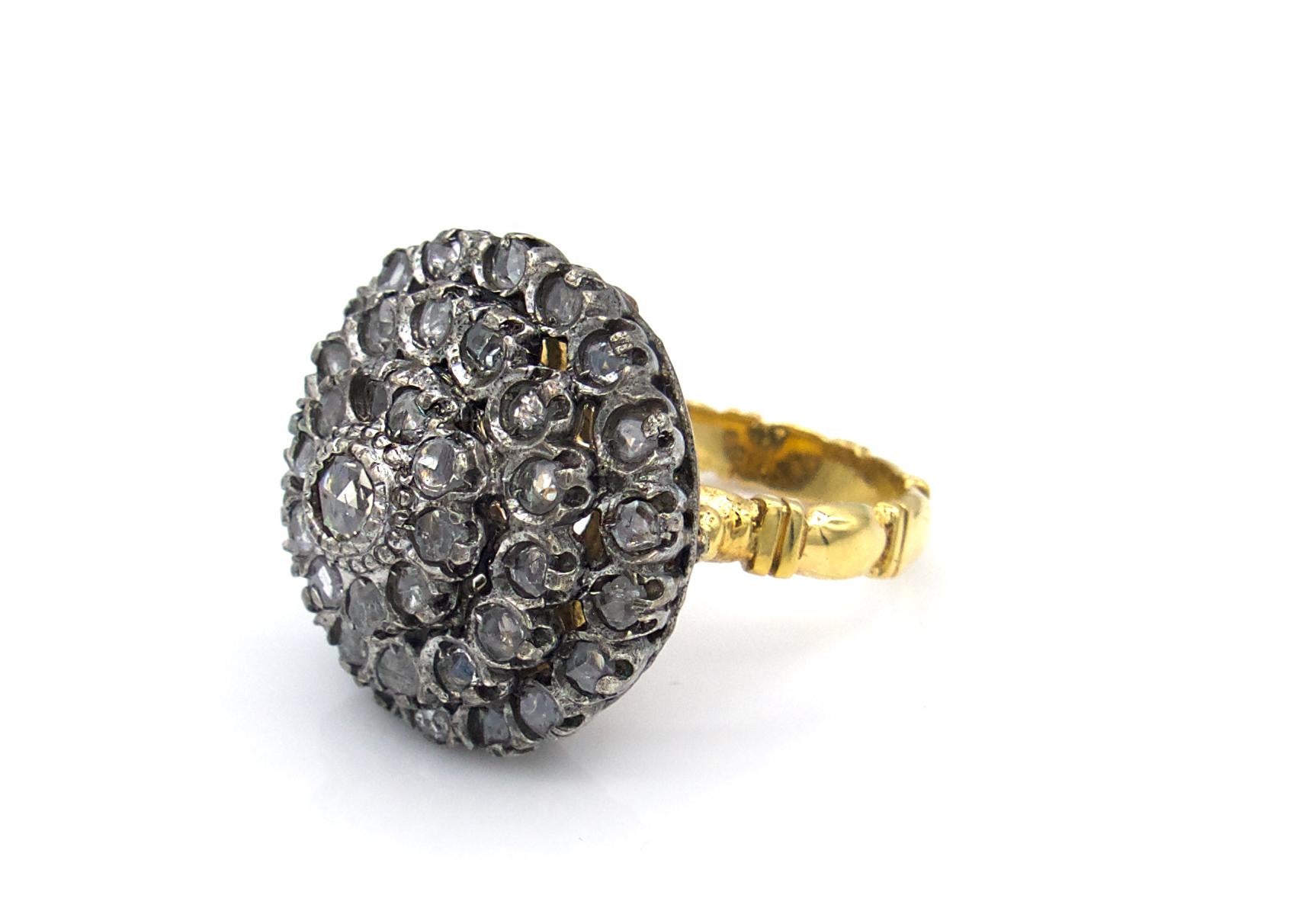 This turn-of-the-century diamond dome ring is set with 43 rose-cut diamonds. The 18 Karat yellow gold band and under carriage have intricate filigree detail work. This piece, like many from the era, also has a sterling silver topping for a two-toned
