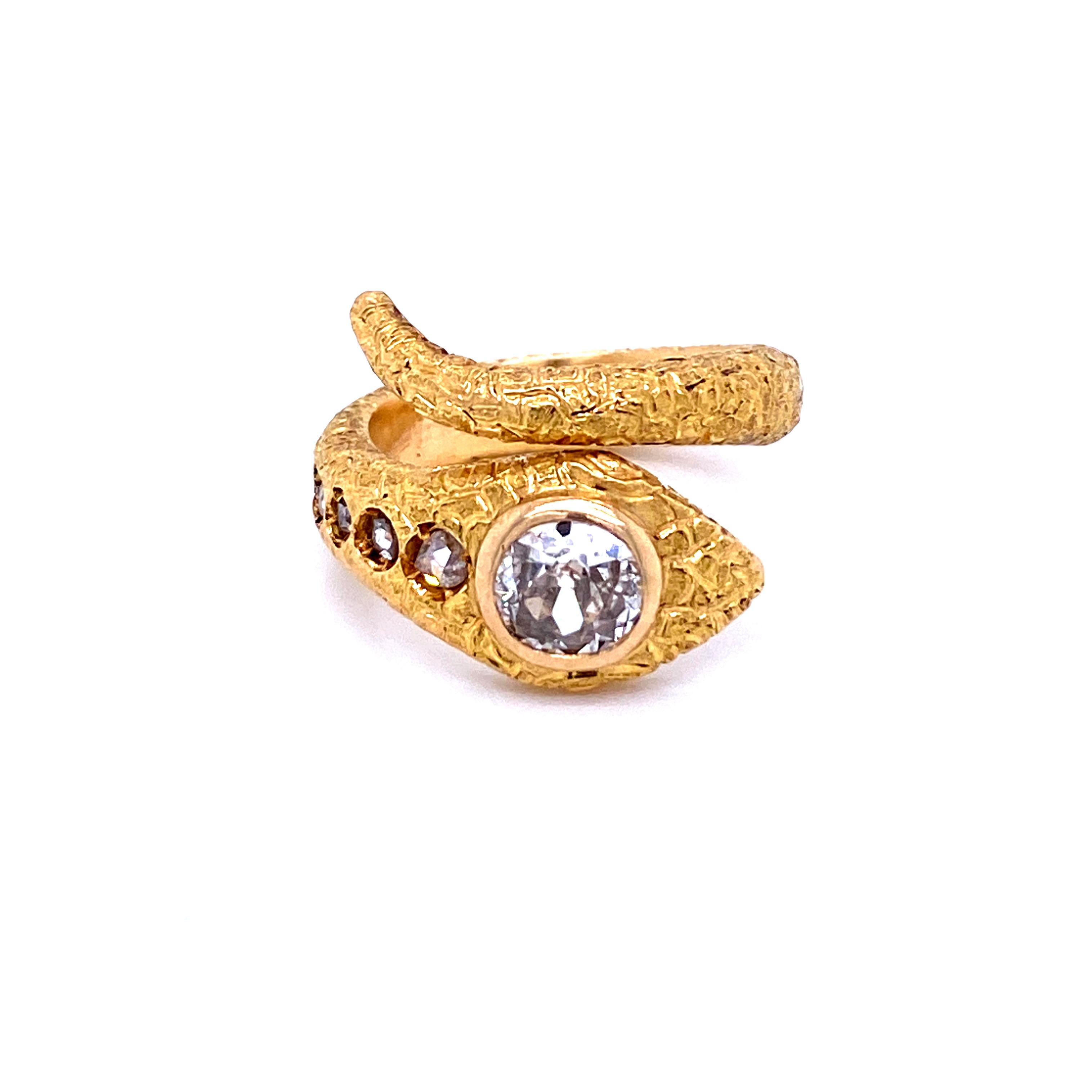 Gorgeous design ring, dated '1900, handcrafted in 18K gold. The head of the snake is embellished with a large sparkling Old mine cut Diamond eye, weight 1 Carat graded I Color Si1, and following 5 smaller diamonds in order of size, total weight 0.25