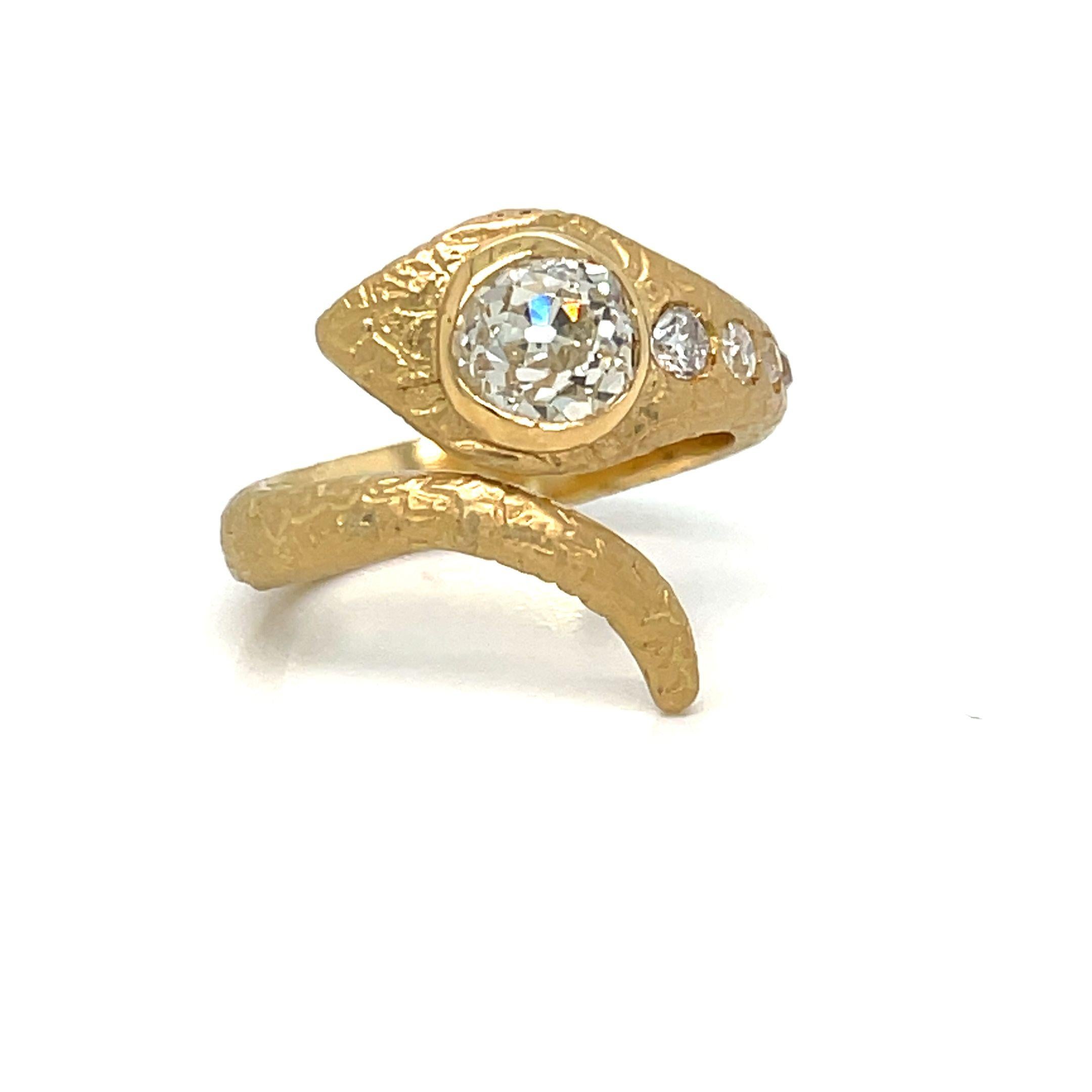 Gorgeous design ring, dated '1900, handcrafted in 18K gold. The head of the snake is embellished with a large sparkling Old mine cut Diamond eye, weight 1,30 Carat graded I/J Color Si2, and following 5 smaller diamonds in order of size, total weight