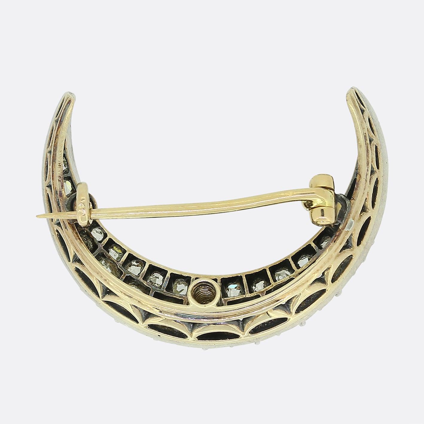 Here we have a charming diamond brooch dating back to the Victorian period. This antique piece has been crafted from old gold and silver into the shape of a crescent moon. This framework has then been set with two rows of chunky round faceted old