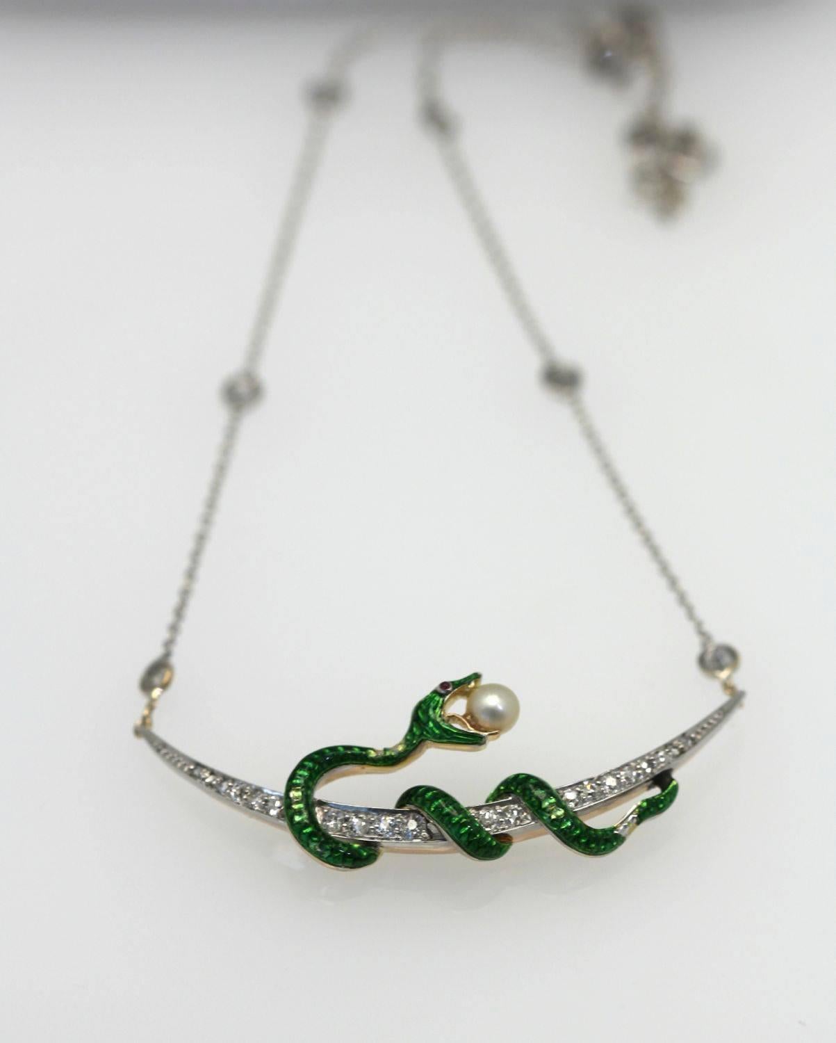 Collier à croissant de diamants avec serpent tenant une perle sur une chaîne sertie de diamants.  L'émail vert est légèrement abîmé, mais cela n'altère en rien la beauté de cette pièce.  Au départ, il s'agissait d'une broche, mais comme elle était