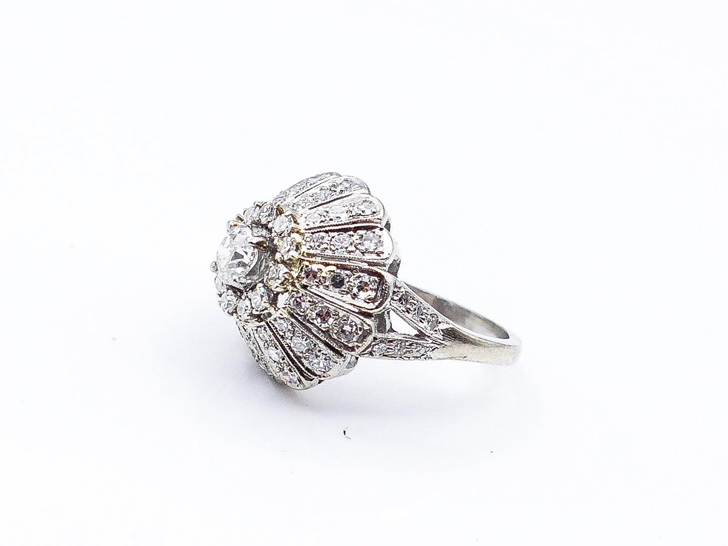 This elegant antique 14 karat white gold, diamond dome ring shines bright with 65 small, pave-set, round diamonds that culminate in petals and peak to a large center, old miner's cut diamond, weighing at 2 carats in total. This 1920's piece is a